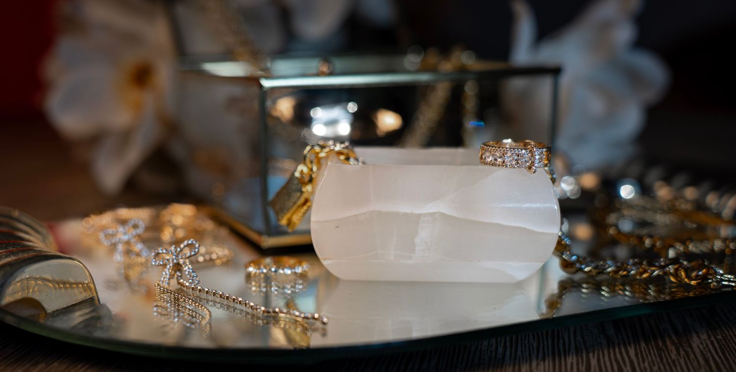 Luxury jewelry pieces with diamonds and gold chains photographed with soft bokeh effect.