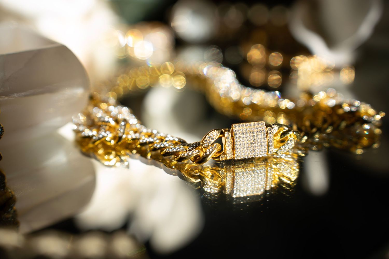 Close-up of fine jewelry with diamonds and gold chains creating an abstract pattern.