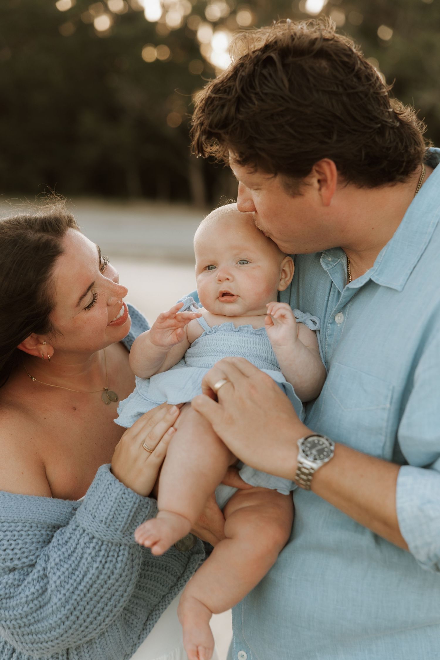 A loving family moment captured in a series of tender outdoor photos with warm bokeh lighting and soft tones.