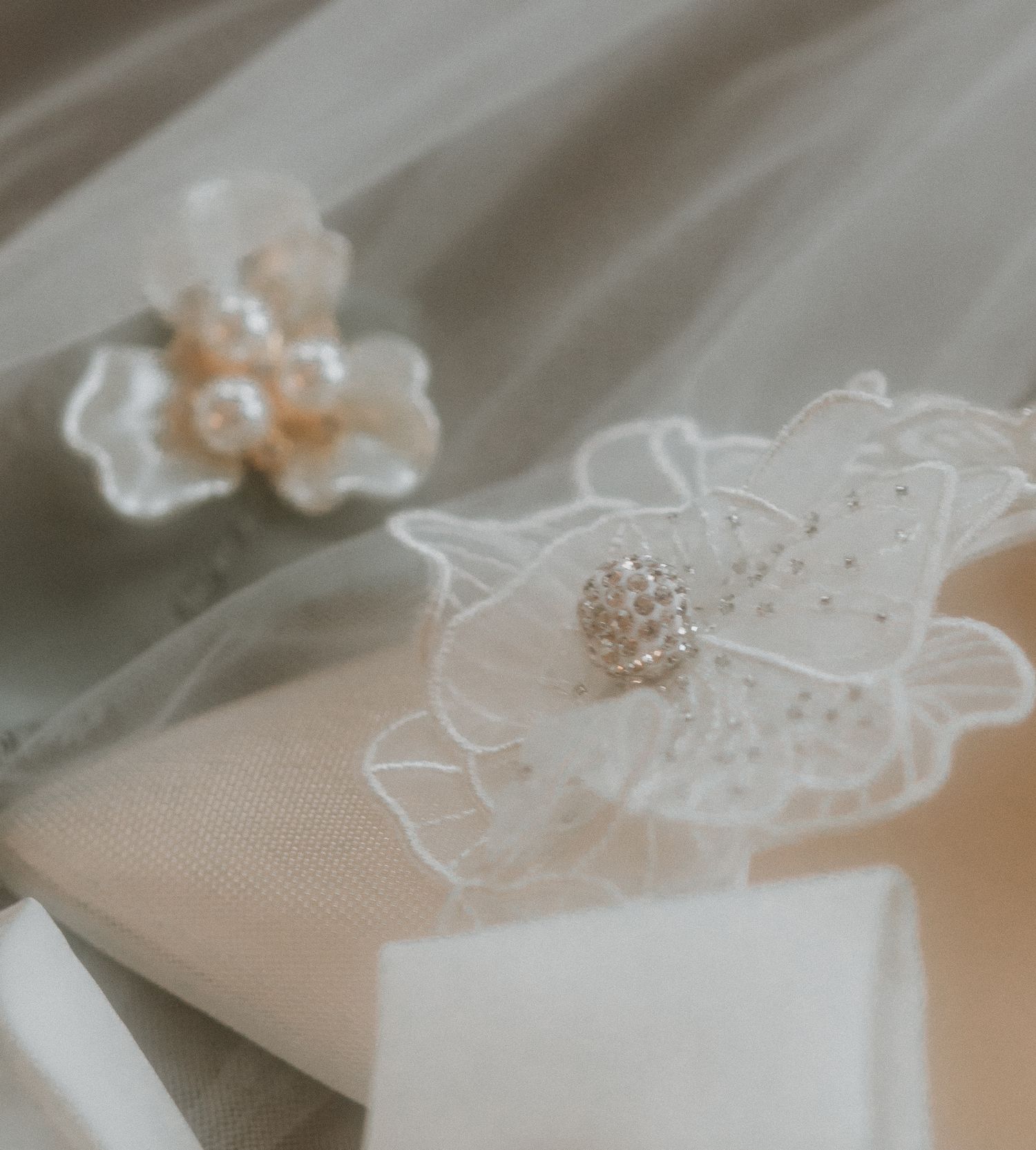 Delicate lace flower detail with pearl embellishment on wedding accessories.