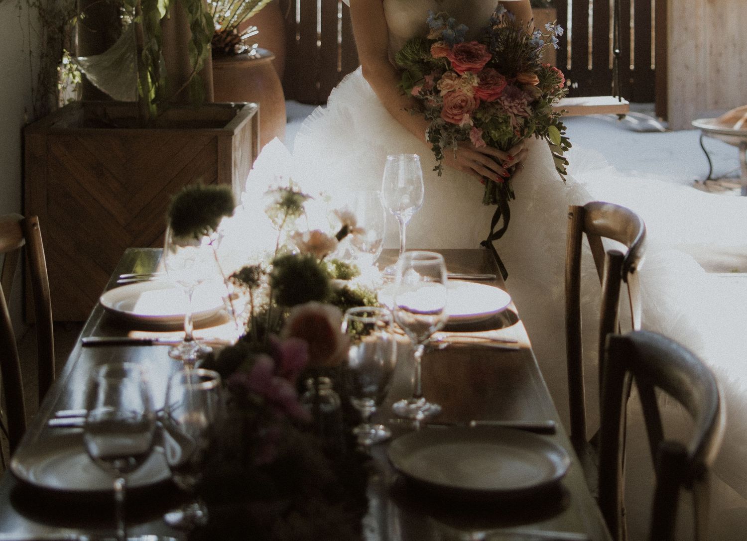 Intimate wedding reception table with moody lighting and floral arrangements.