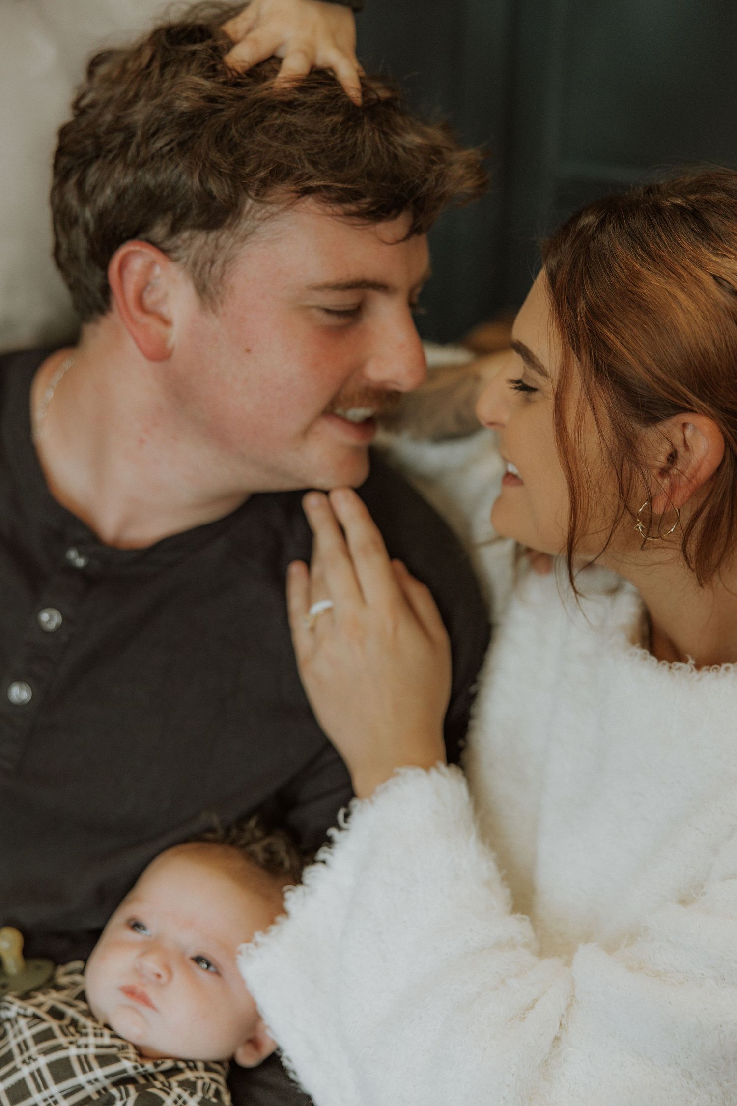 Intimate family moment in cozy sweaters with a baby.