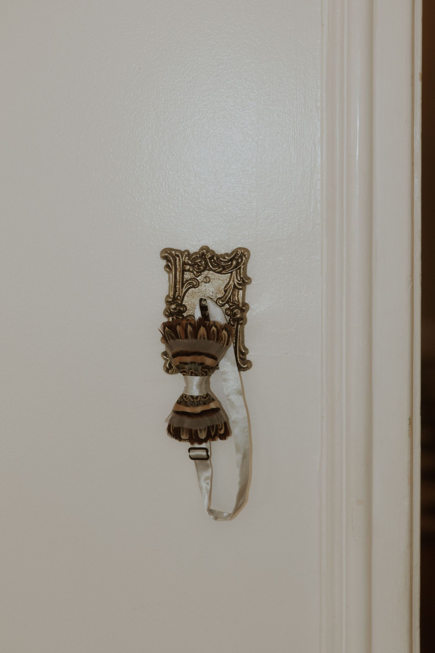 Decorative antique wall sconces and holders mounted on a white paneled wall showcase elegant vintage home decor.