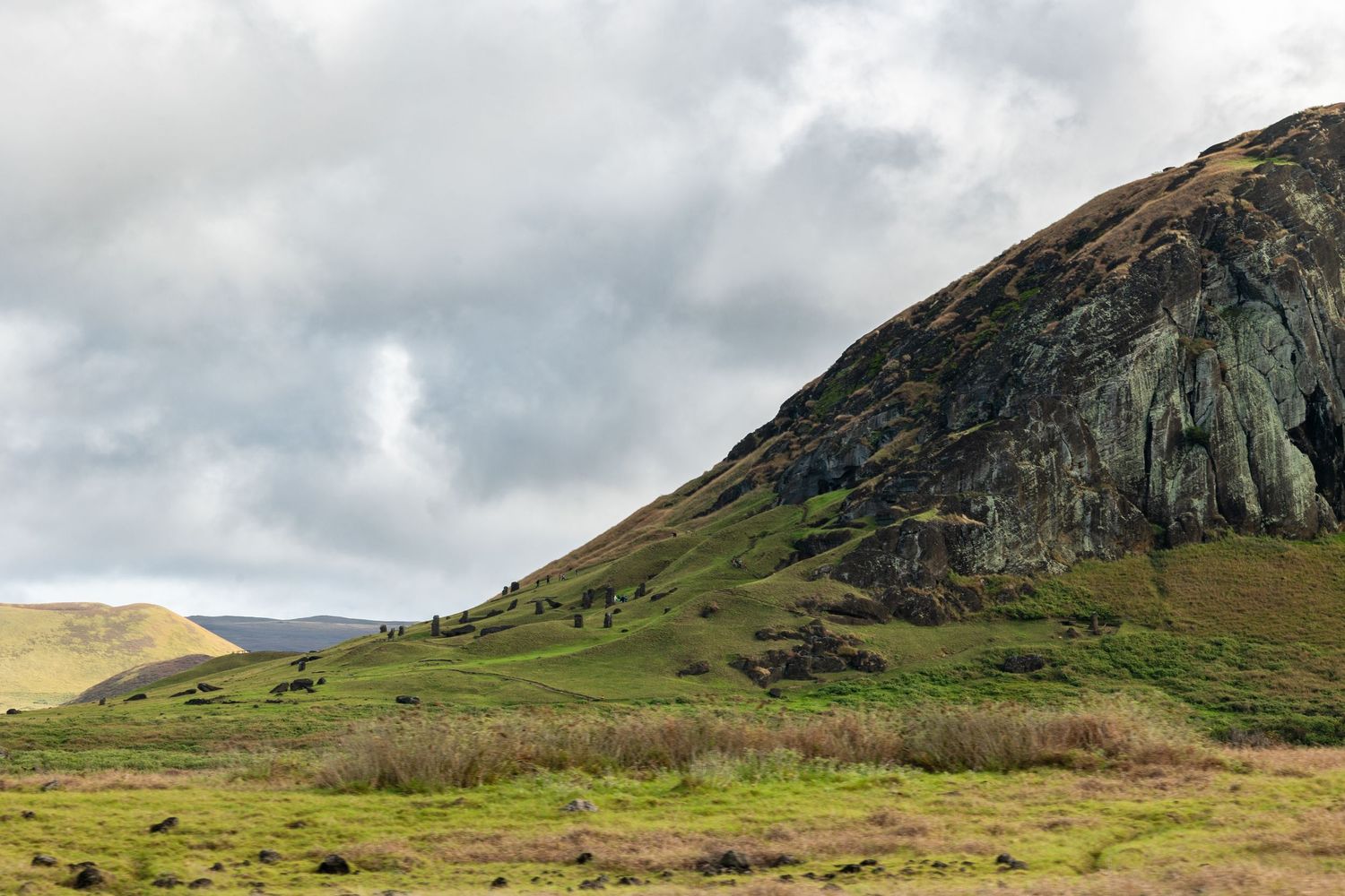 A series of lush green mountainous landscapes with dramatic cloudy skies above steep rocky cliffs in panoramic view.