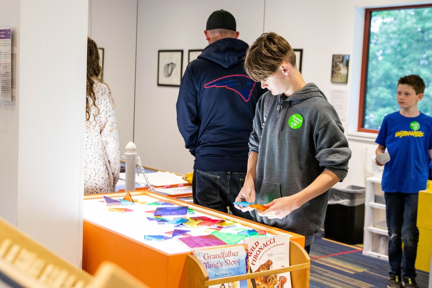 Students working on educational activities and materials at tables in a bright classroom setting.