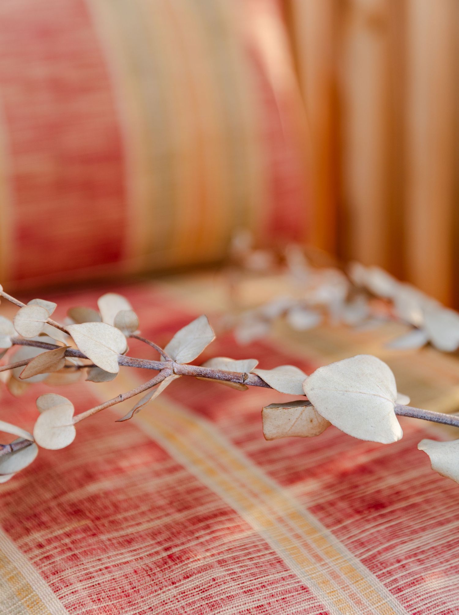 White decorative heart-shaped paper garland resting on a red and white striped textile surface.