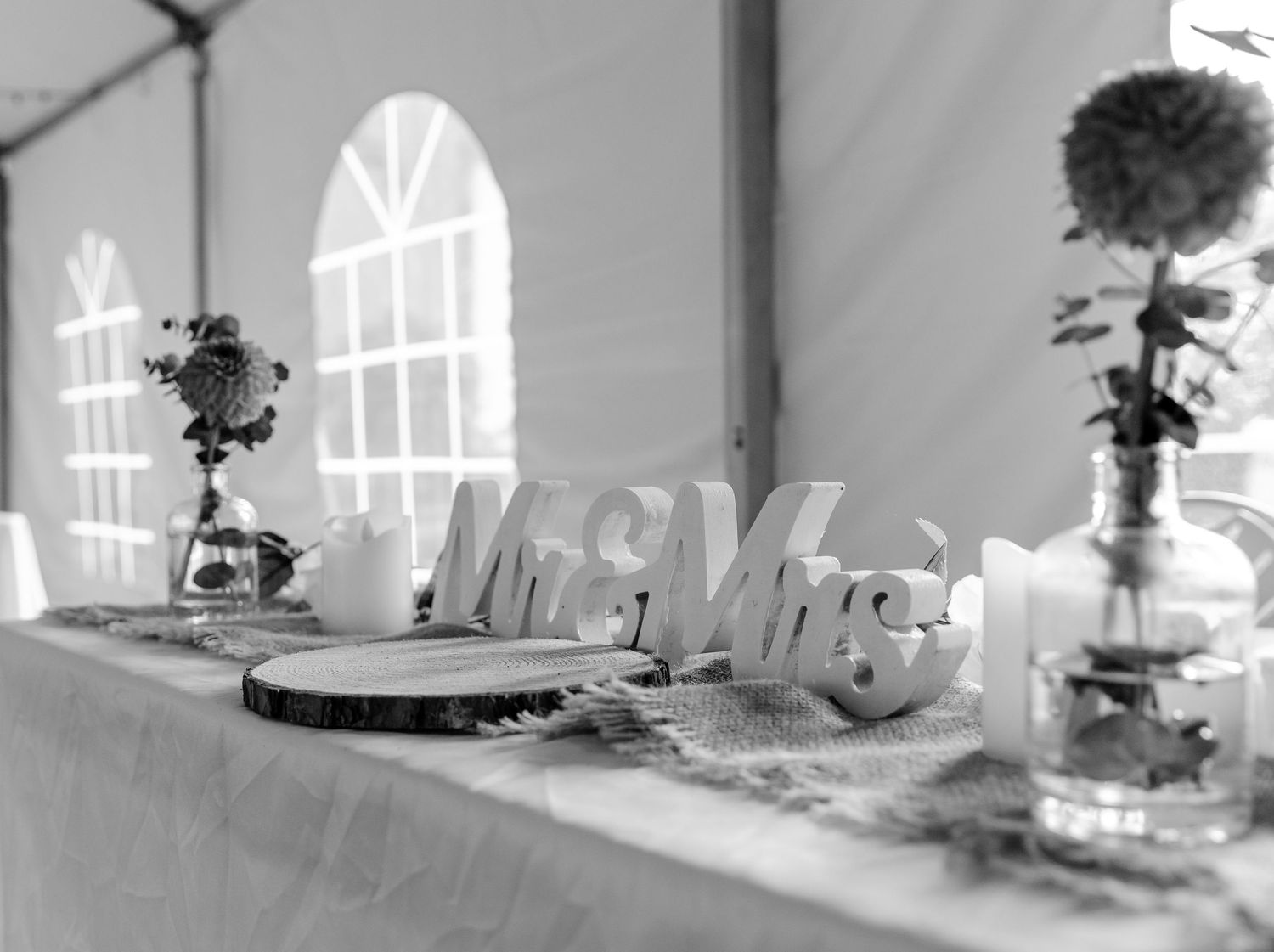 Black and white table setting with Mr & Mrs sign, elegant window light, and floral centerpiece decorations.