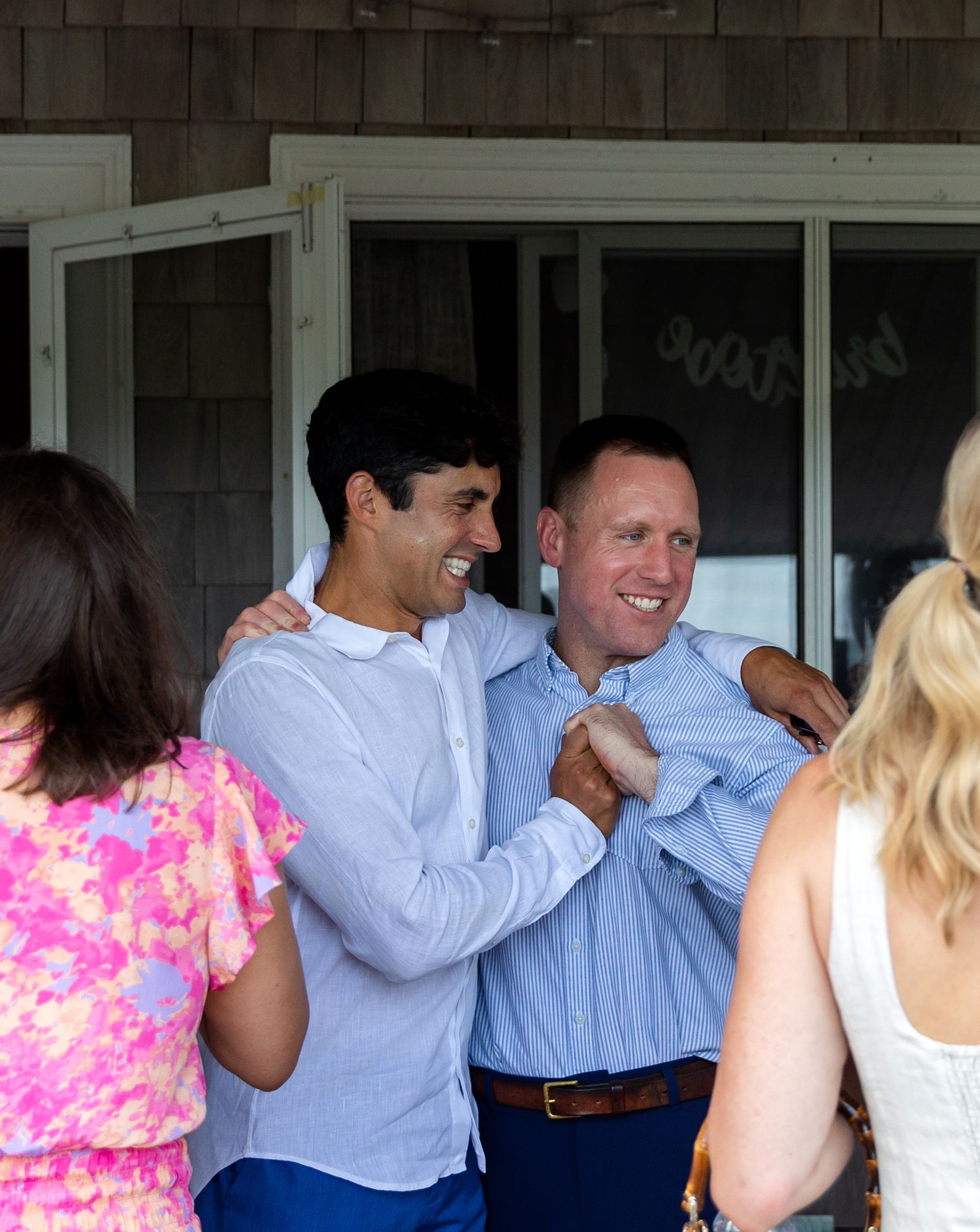 A group of people dancing and having fun at a casual social gathering in a covered outdoor space.