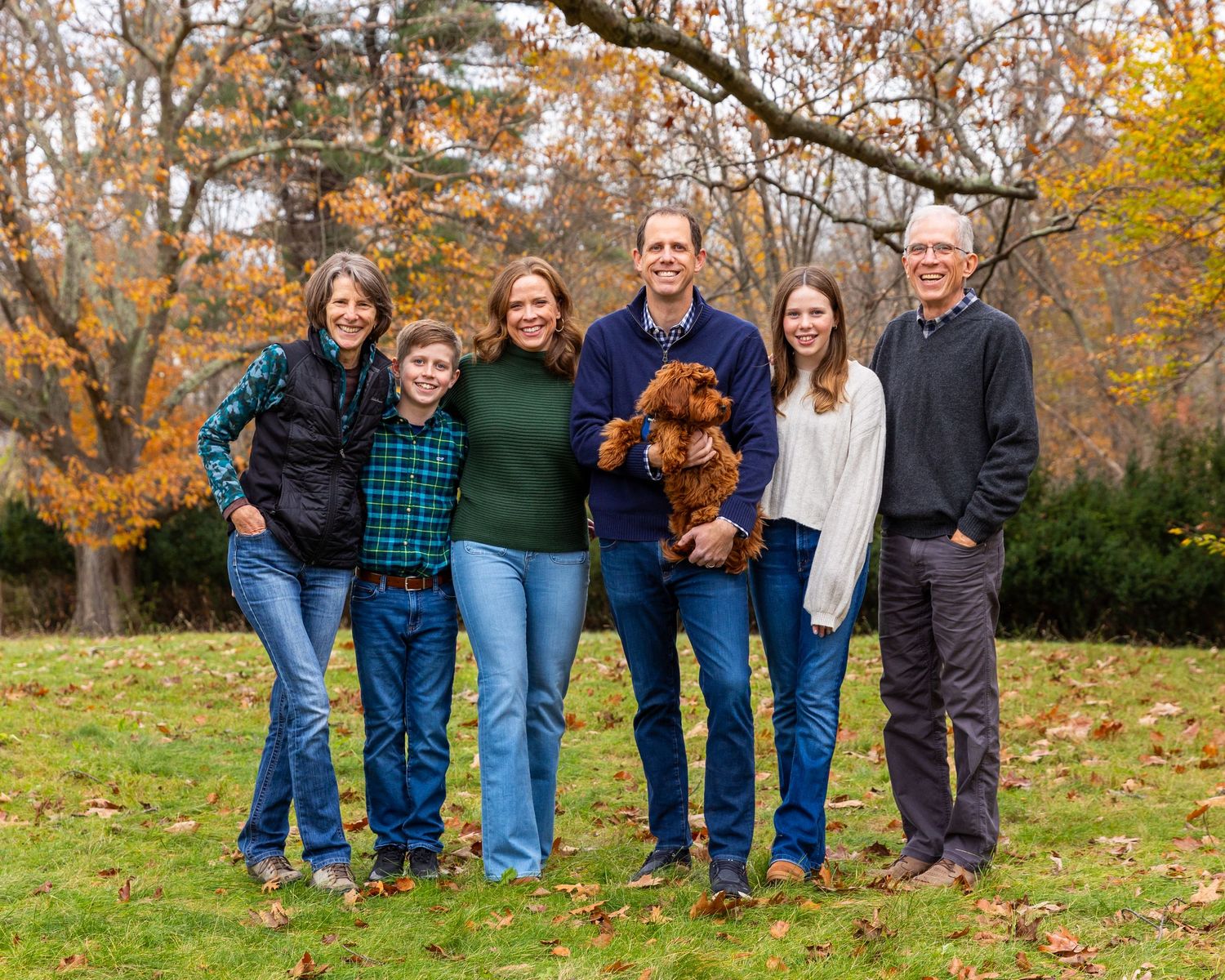 A set of connected outdoor family portraits shows people in casual wear posing together against autumn trees and foliage.