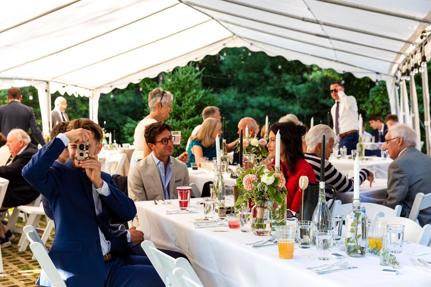 A row of connected photos shows guests dining and socializing at outdoor wedding reception tables.