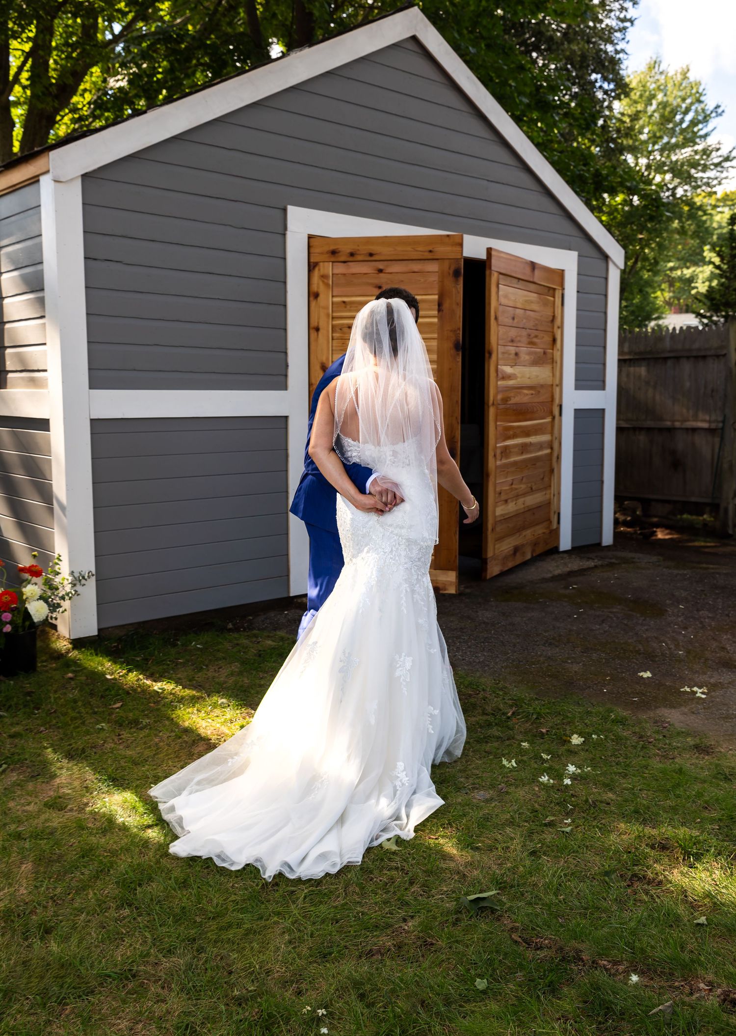 Four photos showing a white wedding dress flowing in the backyard with a gray storage shed in the background.