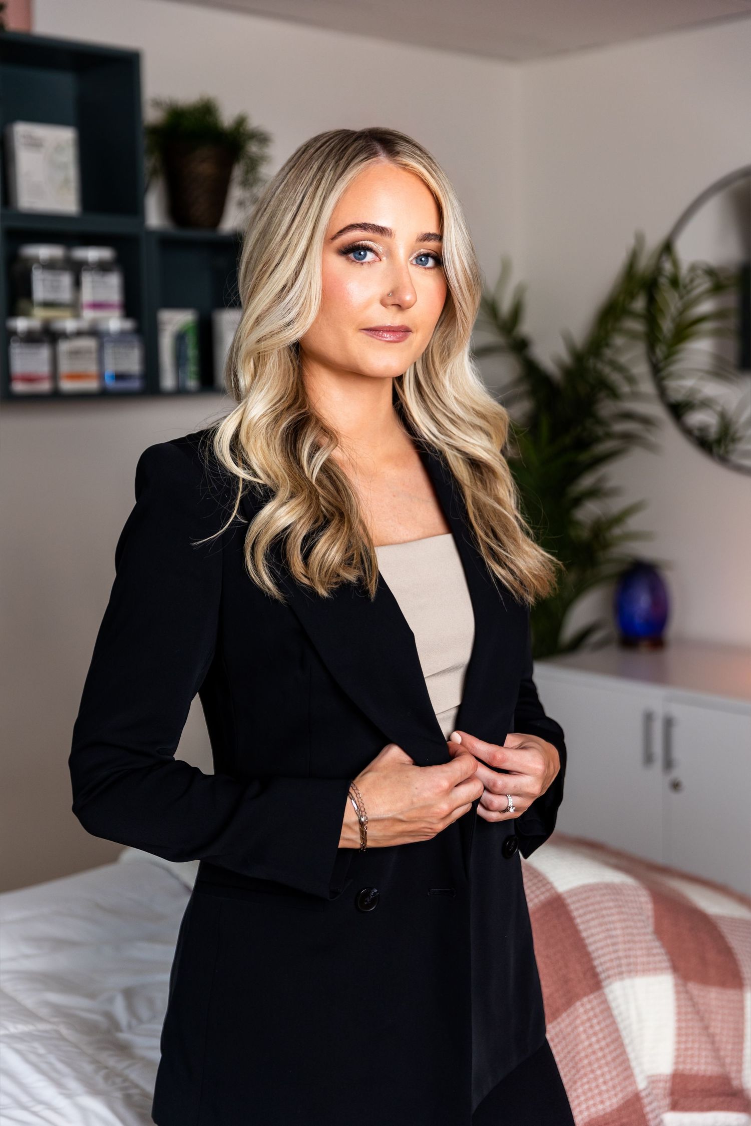 Fashion blogger demonstrating styling versatility of a classic black blazer paired with neutral tops.