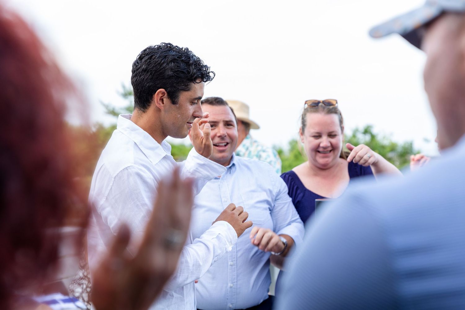 A group of people sharing a cheerful moment together while wearing white dress shirts outdoors.