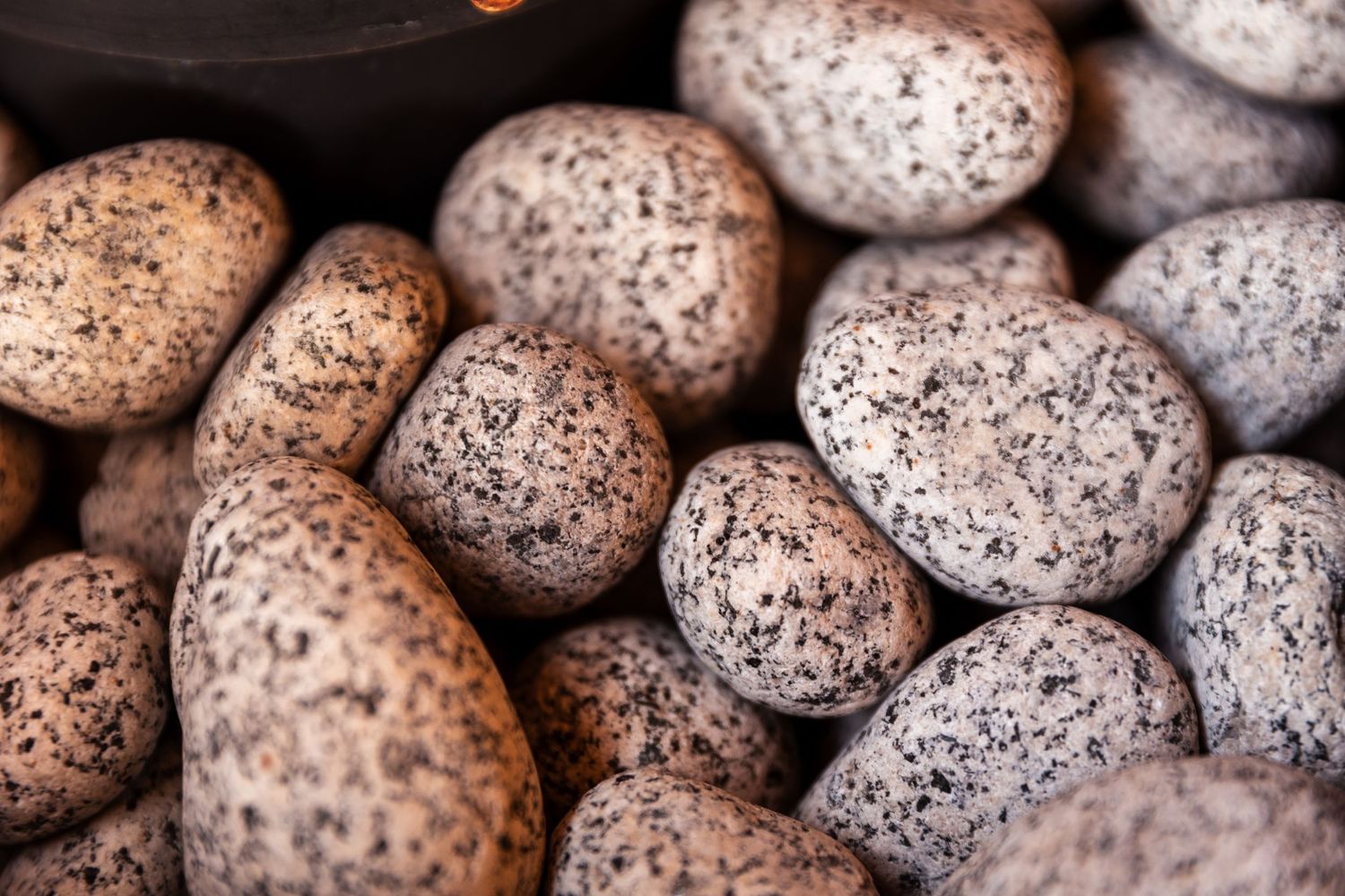 Close up of speckled quail eggs arranged in a pattern showing their natural brown and gray spotted shells.