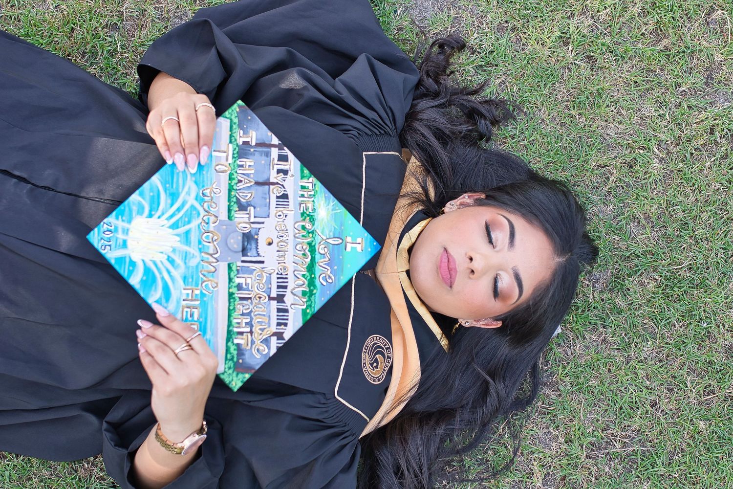 A person lying on grass while holding a carton of milk up towards the sky.