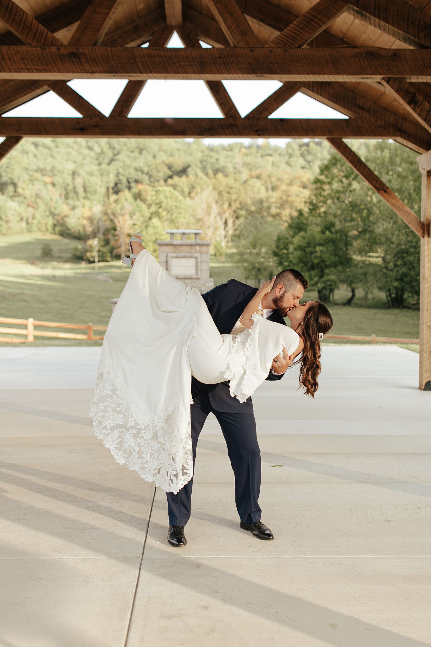 groom picks up bride and dips her into a beautiful kiss at their wedding