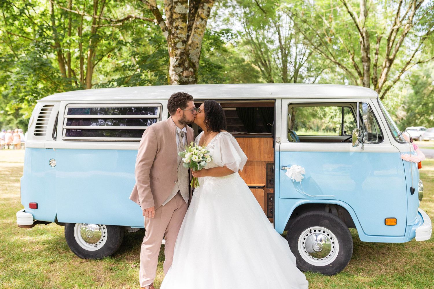 Mariés posant devant un van vintage bleu au Centre du Vignaud à Rives-d'Autise, reportage mariage original et champêtre en Vendée.