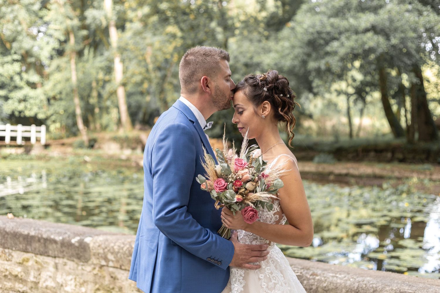 Portraits de mariés avec bouquet bohème en pampa devant le Logis de Mauzay à Échiré, photographe de mariage Deux-Sèvres.