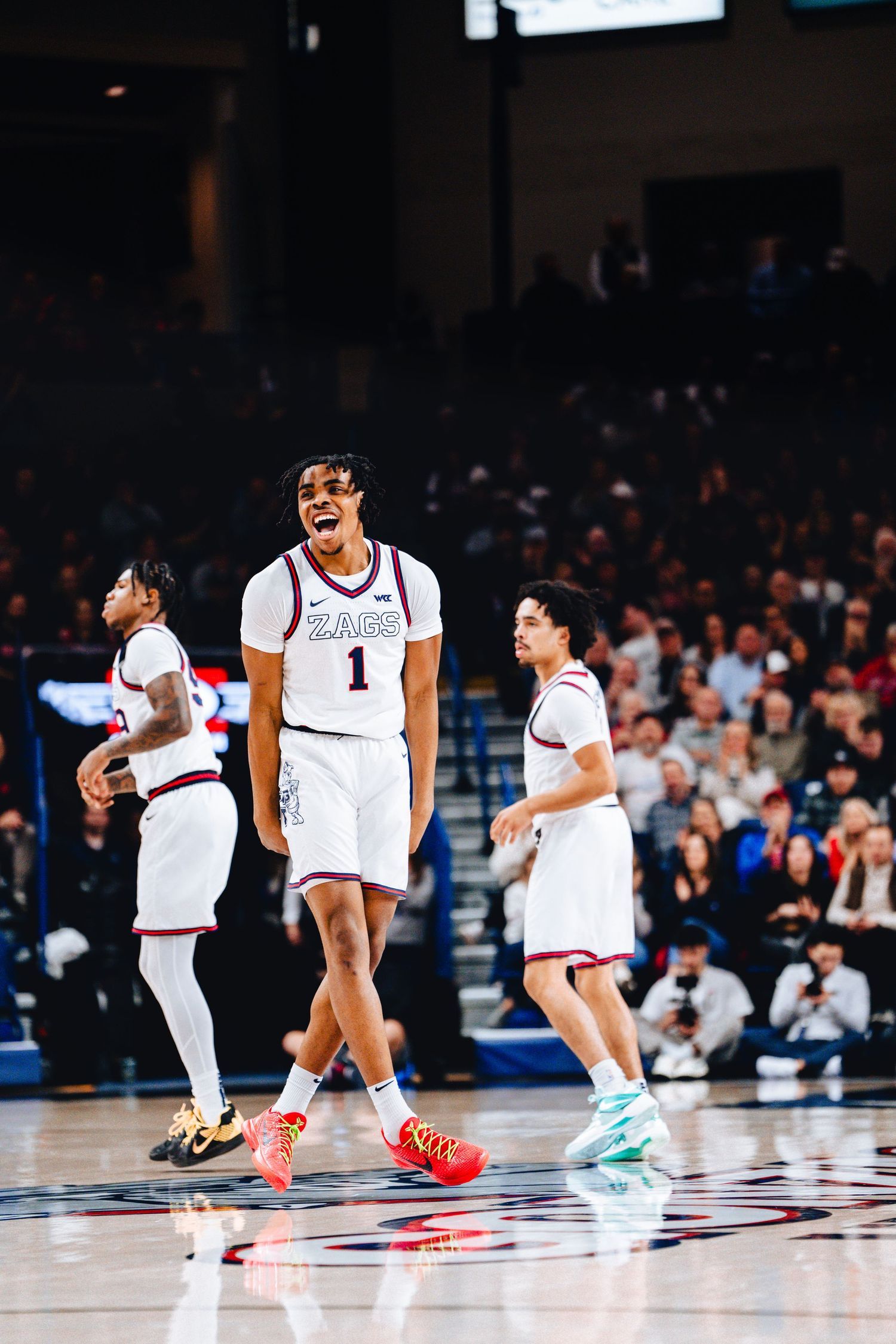 Basketball player wearing jersey number 1 in white uniform celebrates during an intense game on the court.