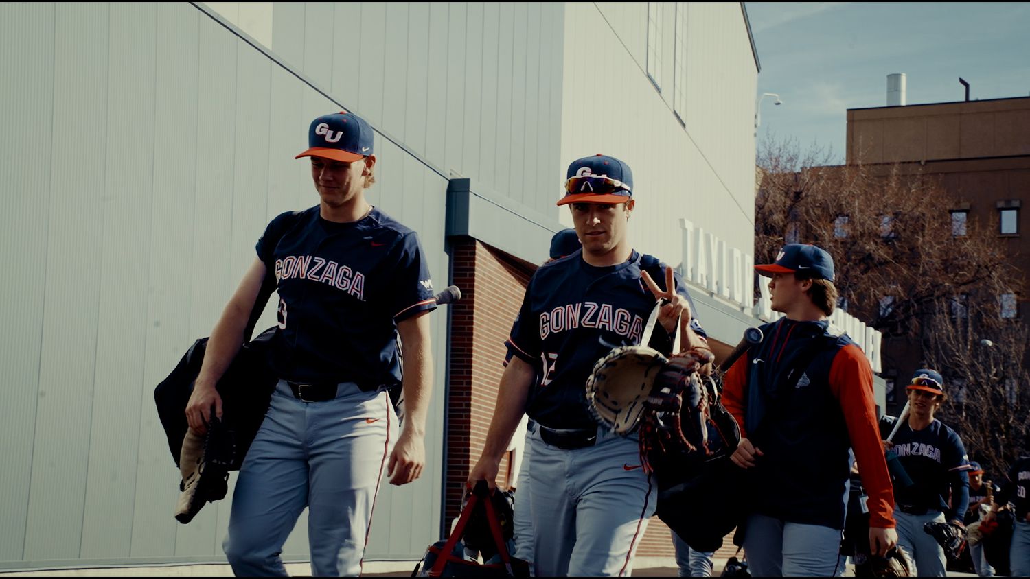 Baseball players in blue uniforms celebrate on the field after winning a game.