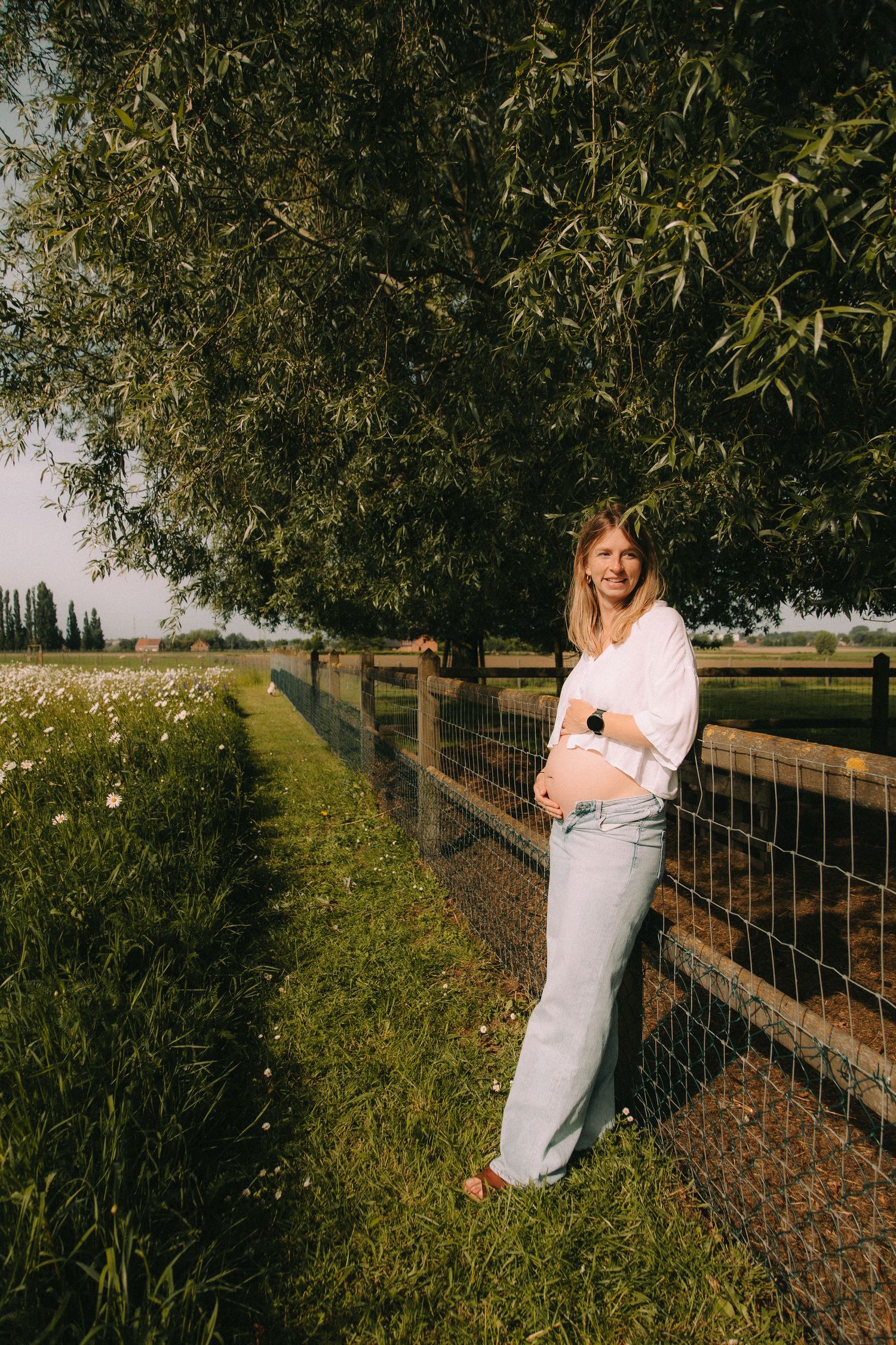 Zwangere vrouw die trots poseert met haar buikje.