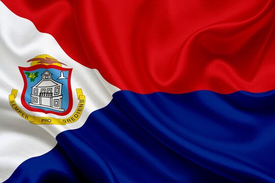 Waving flag of Sint Maarten with red, white, and blue stripes and coat of arms.