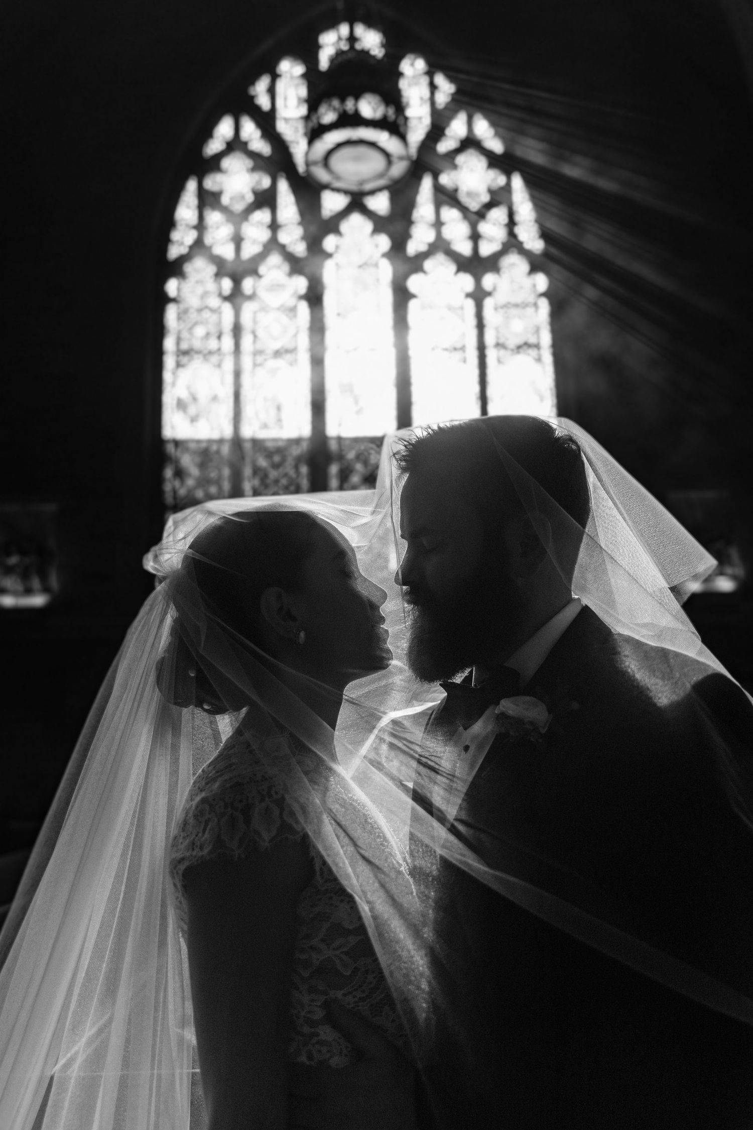 A series of silhouetted wedding photos showing a bride and groom in front of stained glass church windows.
