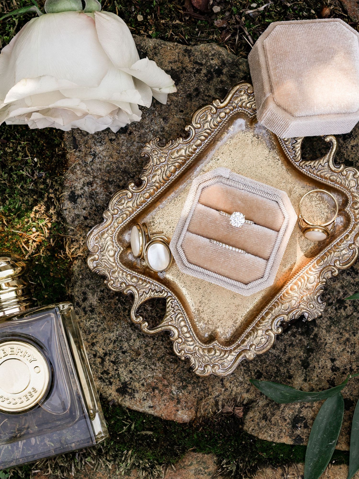 Elegant vintage silver ring boxes and jewelry displays arranged on a rustic stone surface with natural lighting.