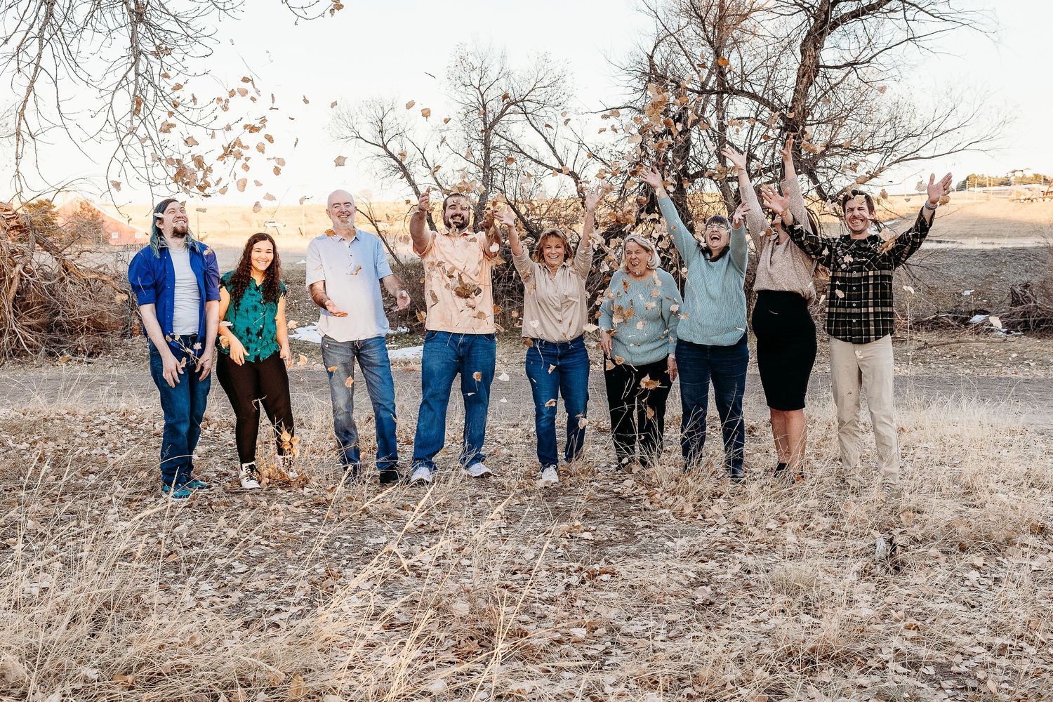 Extended family portrait session in a rustic field with natural lighting.