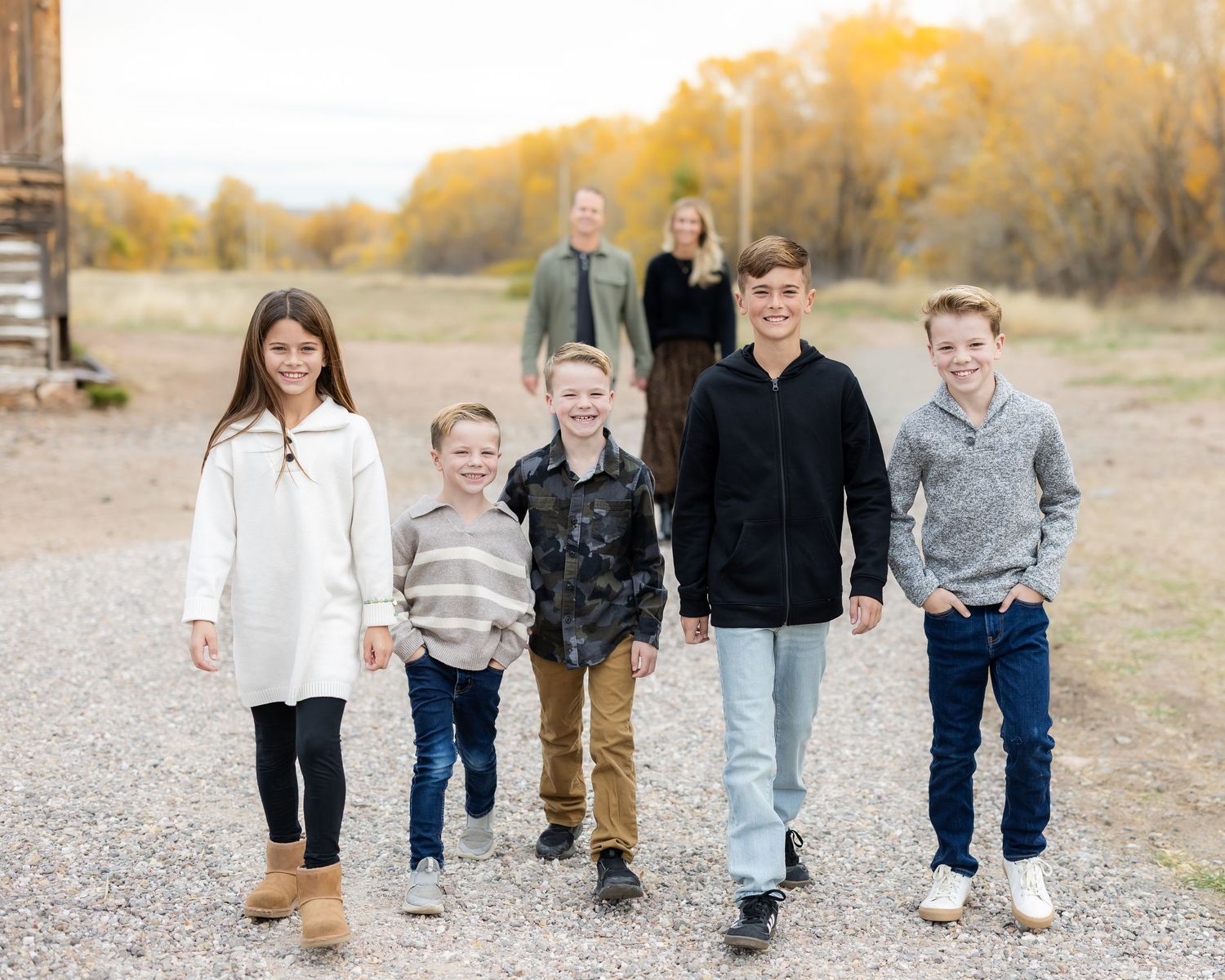 Family members walking together on a gravel path during golden hour.