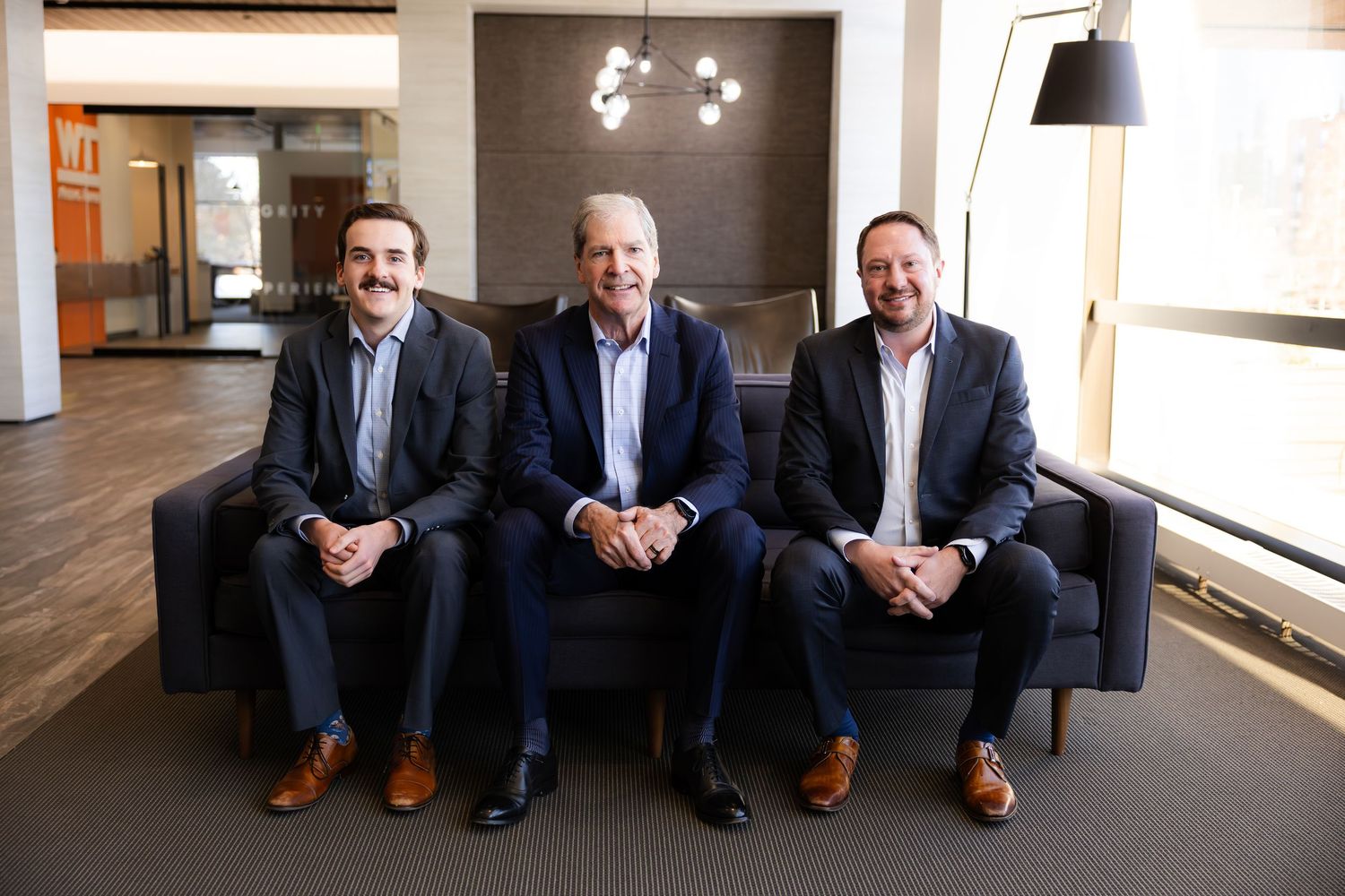 Corporate team photo series showing professionals seated on brown leather chairs.