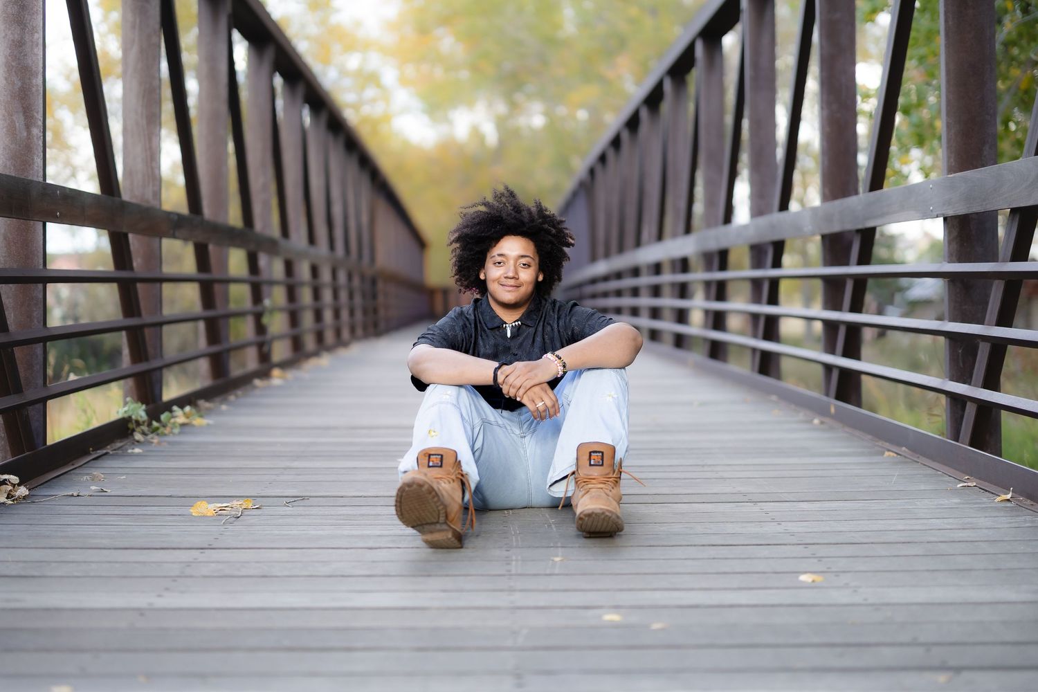 Creative portrait series on wooden bridge walkway with natural lighting.