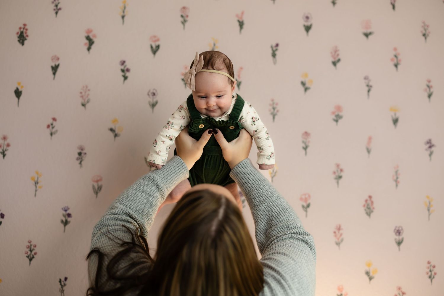 Indoor lifestyle photoshoot with floral wallpaper backdrop.