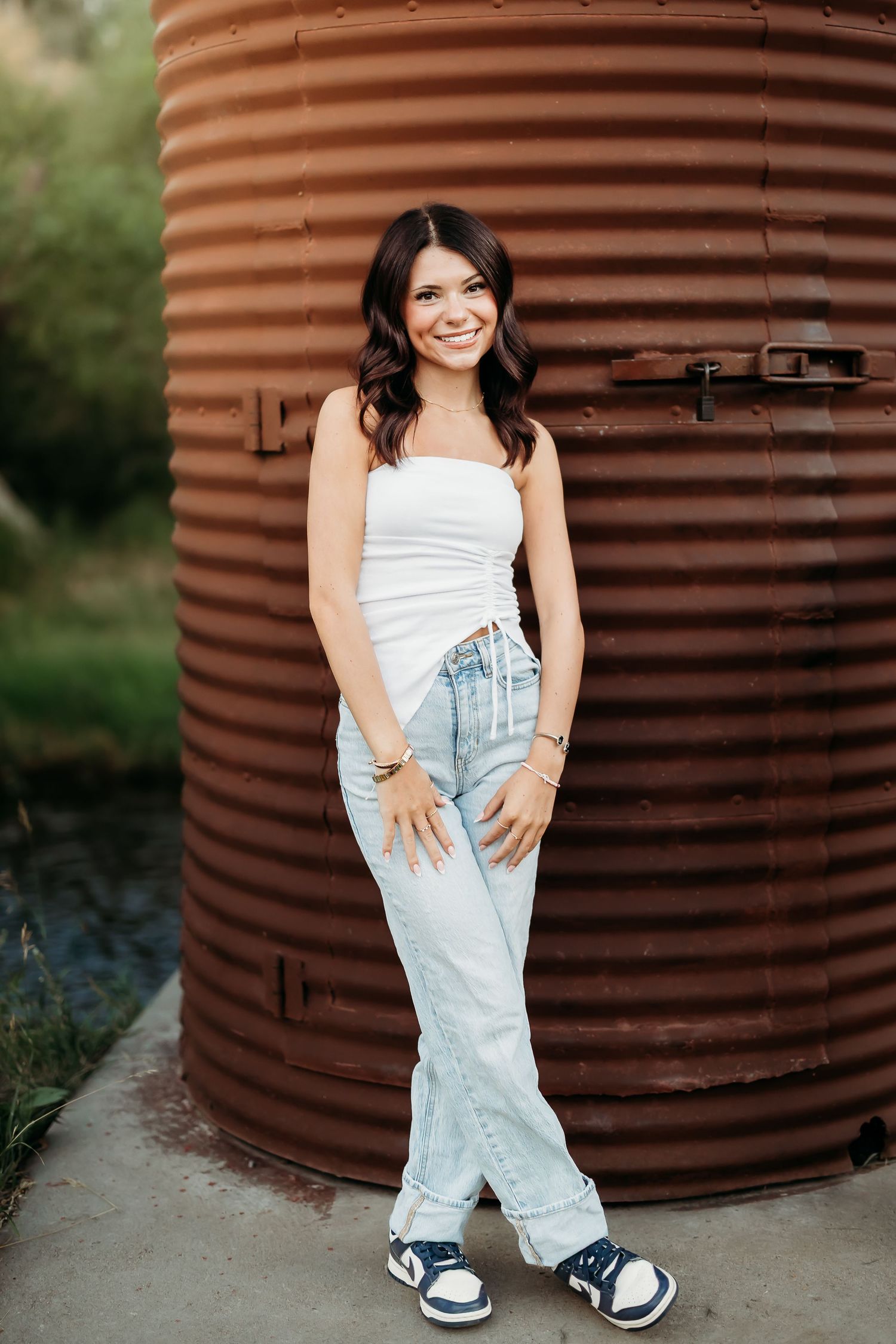 Casual summer outfit posed against rustic metal silo backdrop.