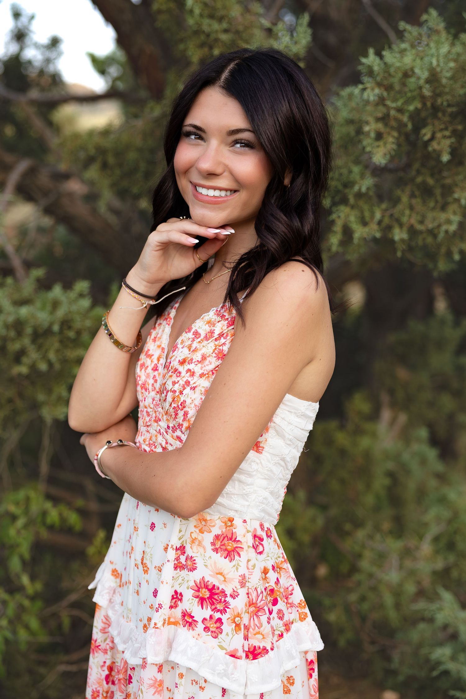 Portrait in floral dress against natural outdoor background.