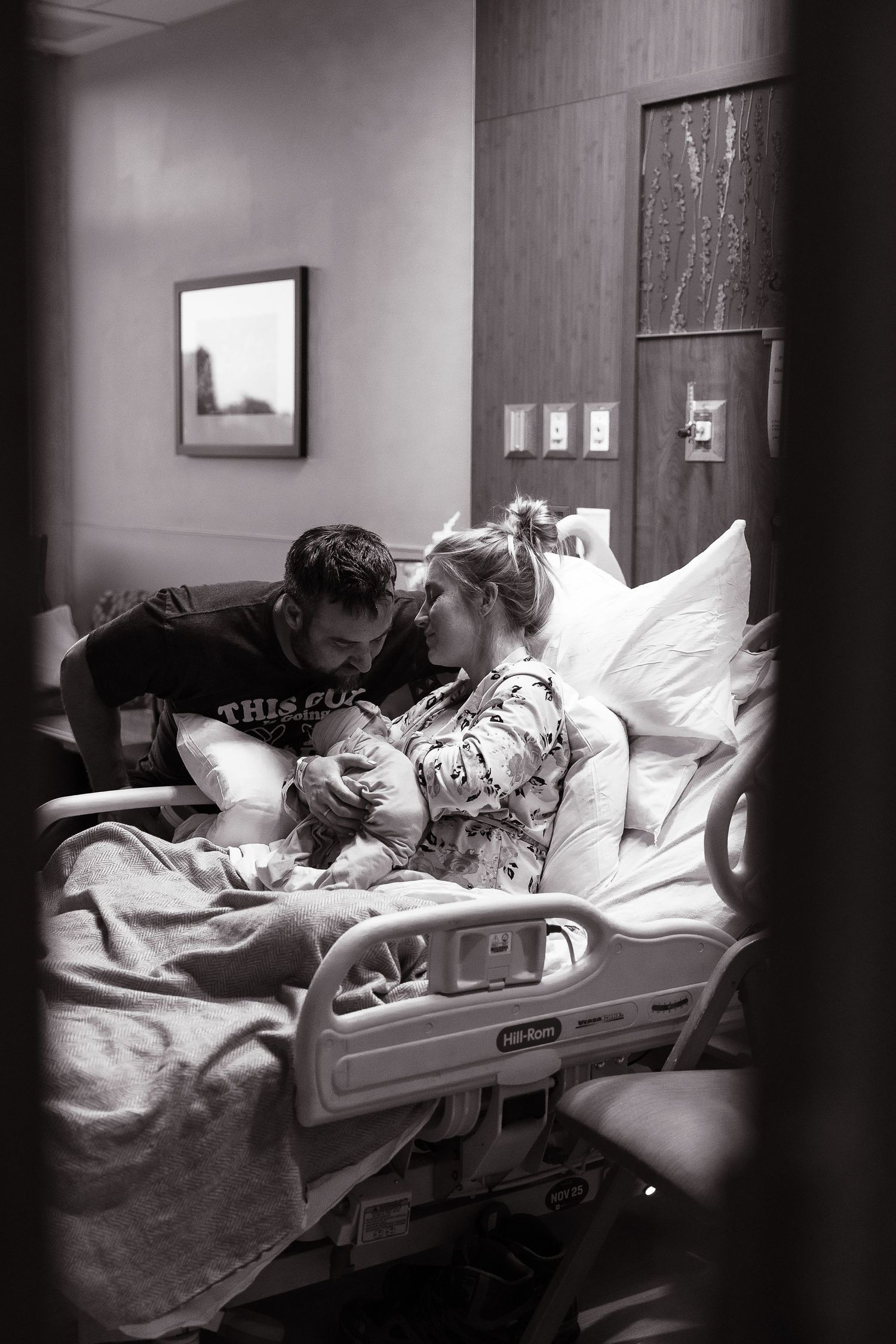 Black and white photo of a hospital room with medical equipment and bed.