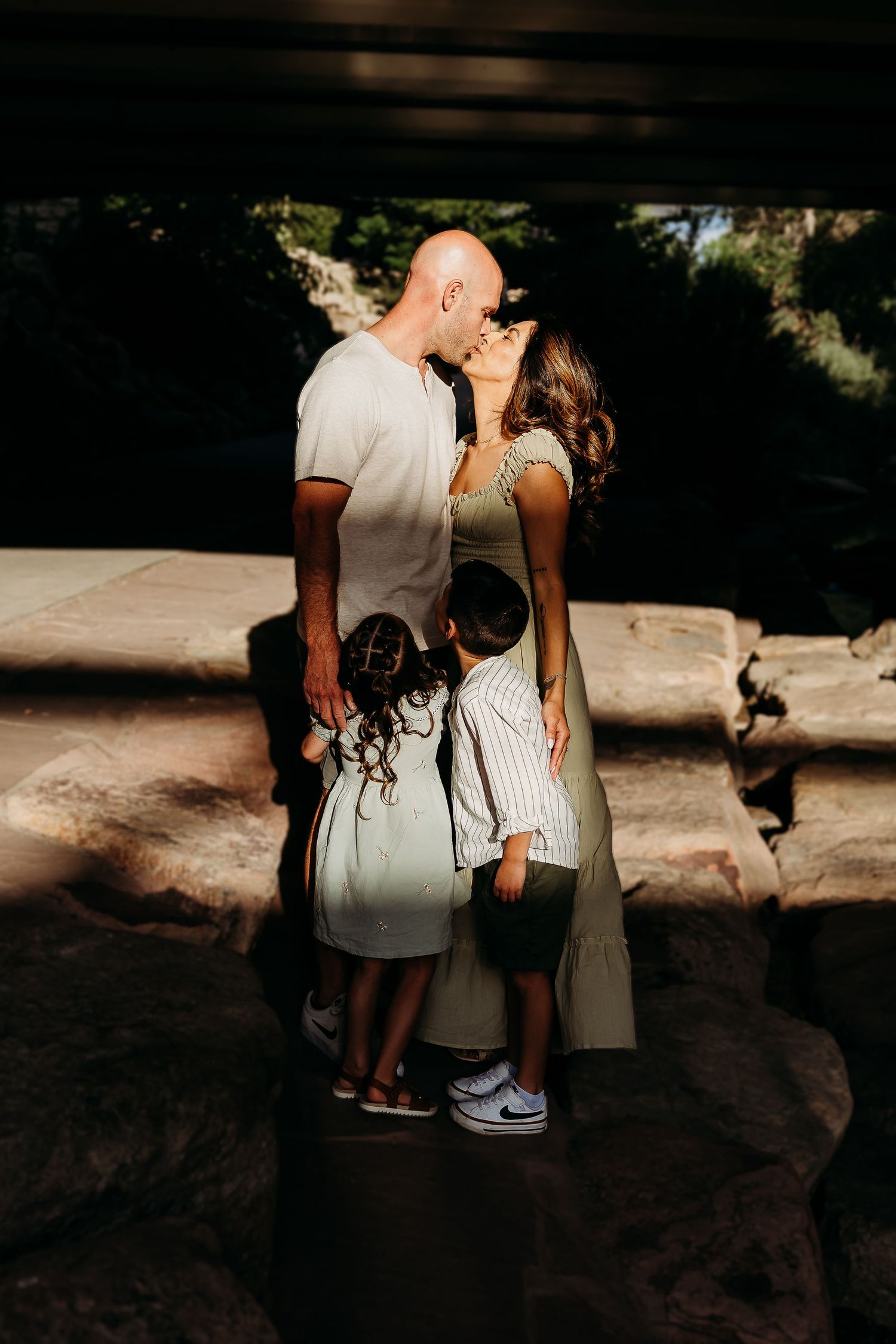Artistic silhouette photo shoot on textured rocks with dramatic lighting and shadows.