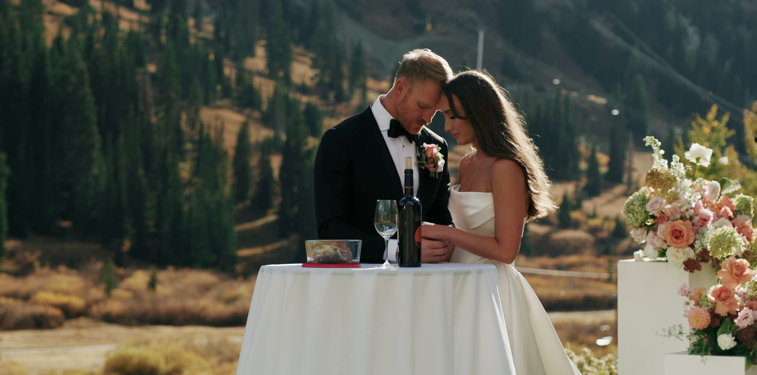 Anna and Cameron praying together during their intimate wedding ceremony at Snowpine Lodge in Alta, Utah, surrounded by the mountains.