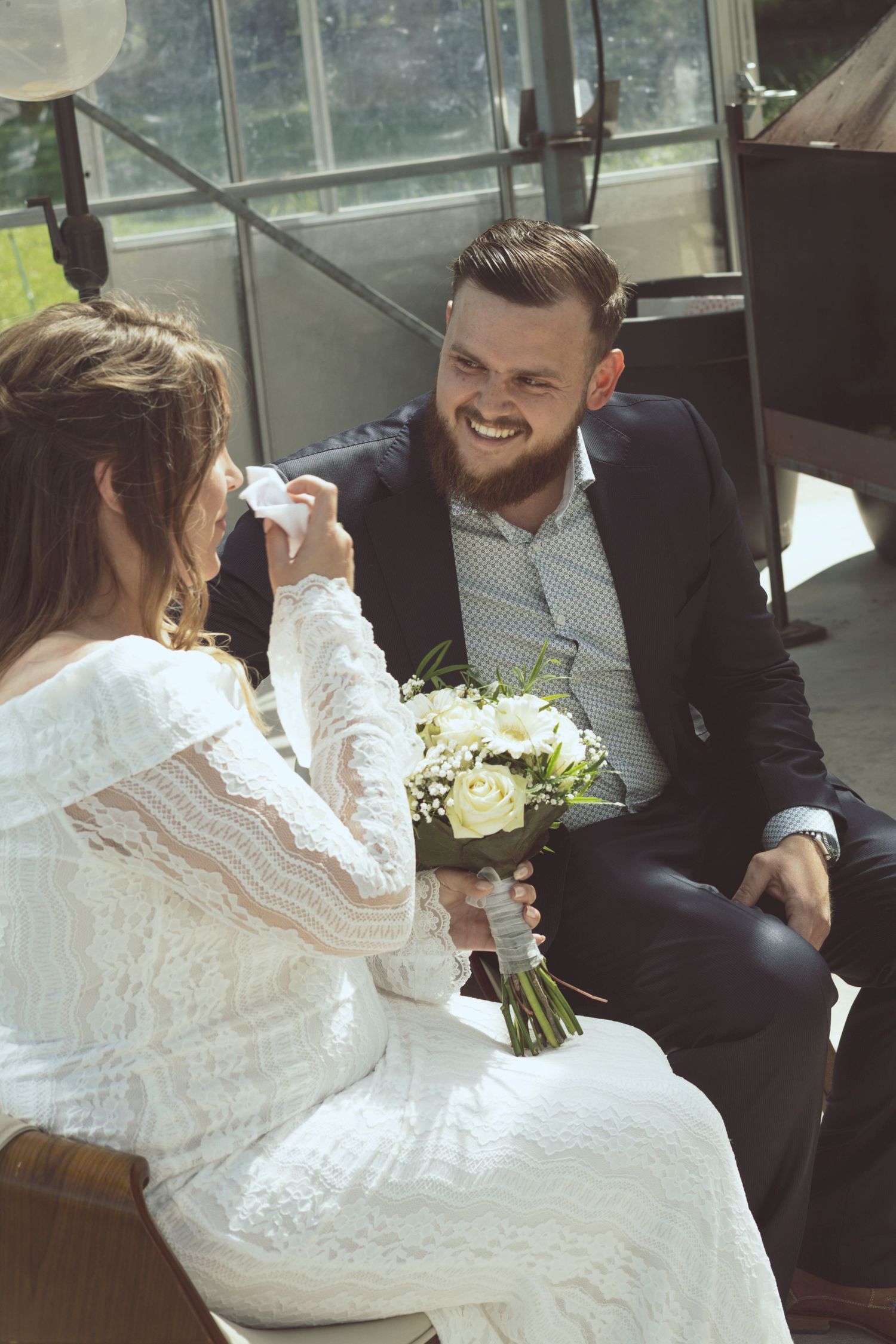 SittingA candid moment of guests reacting during a heartfelt wedding speech together, talking and laughing without direction