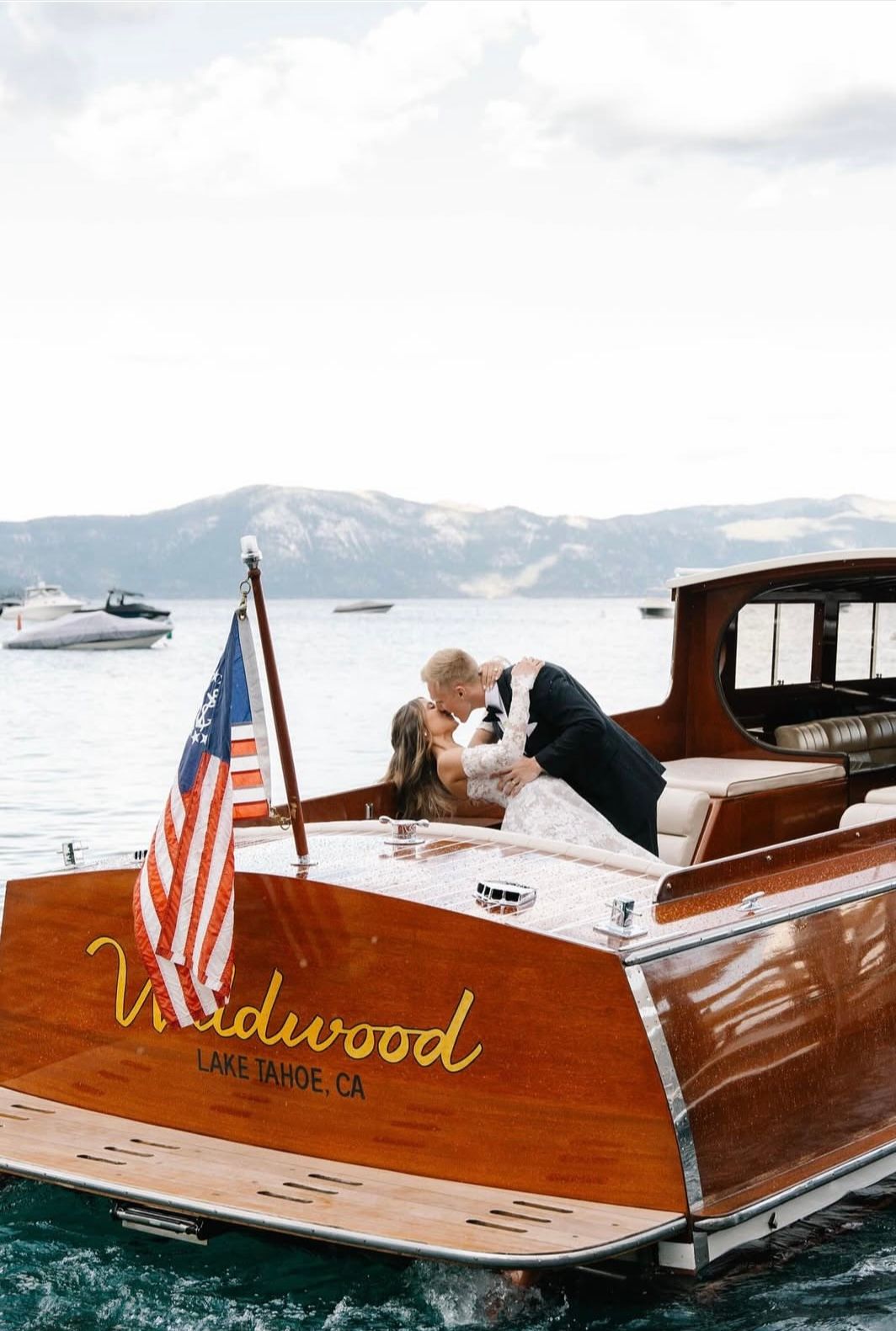 couple doing a kiss dip on a wooden boat in Lake Tahoe. Elopement photo
