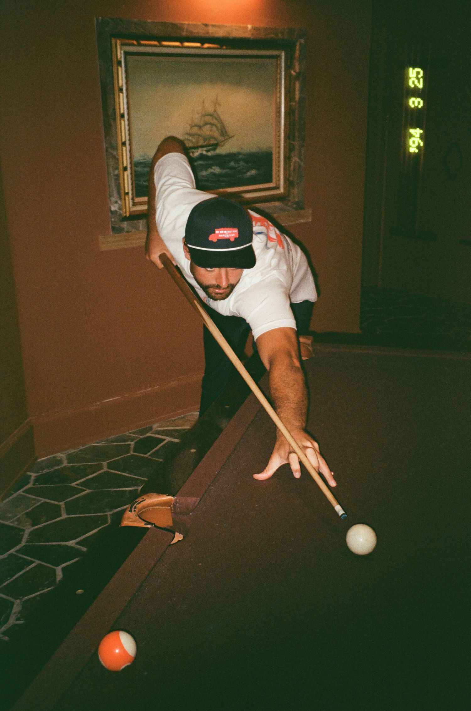 Man in branding playing pool