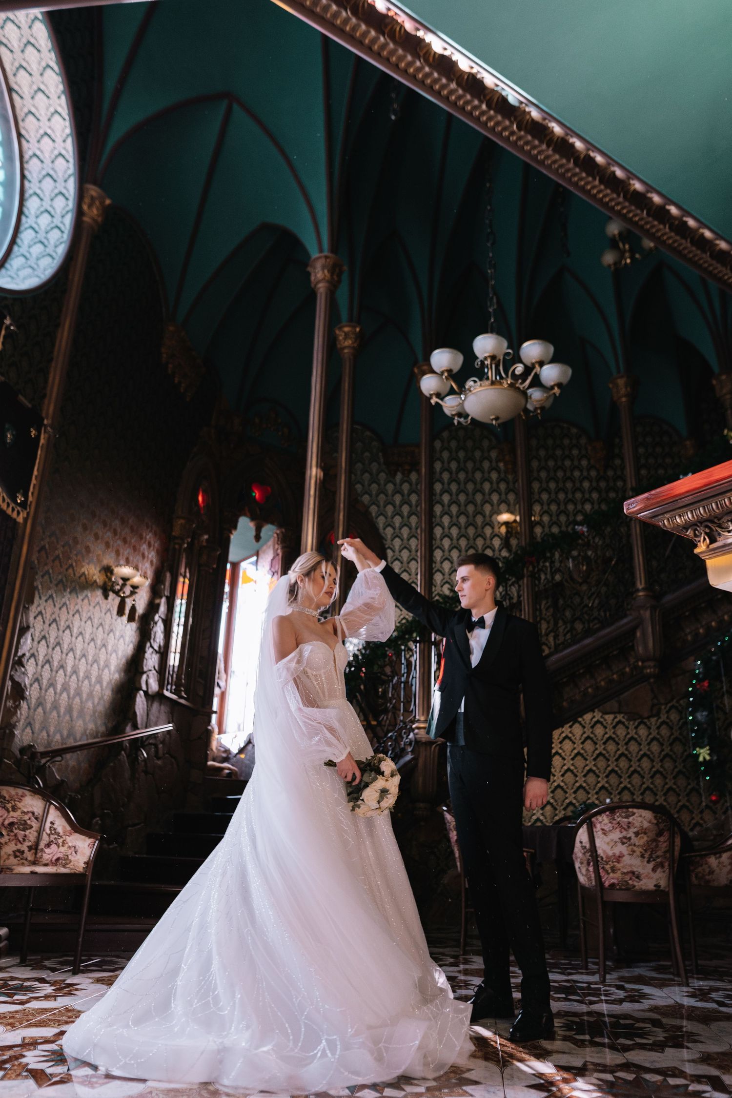 A romantic wedding scene unfolds in a vintage-style room with ornate decor and dramatic lighting.