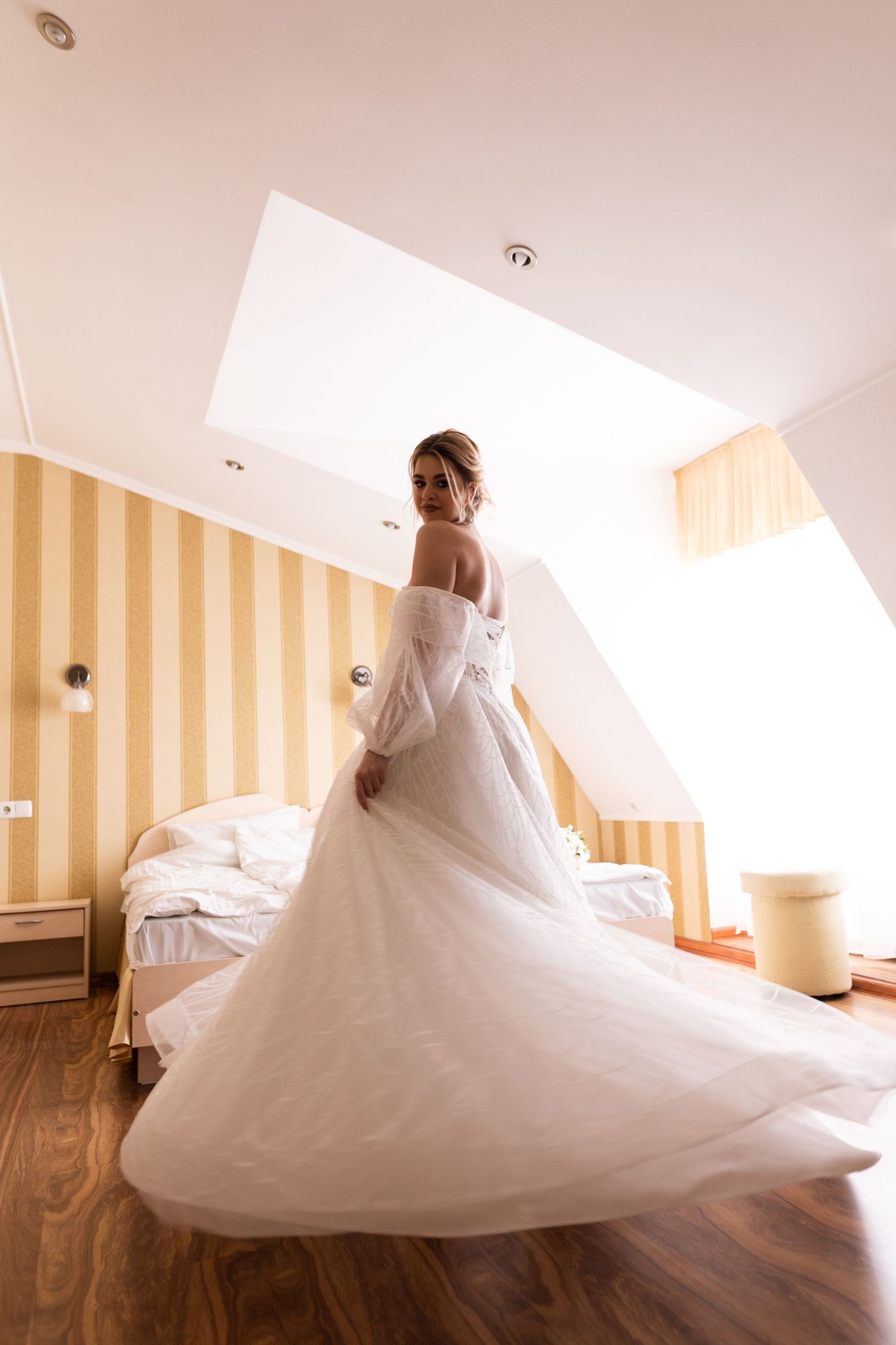 A flowing white wedding dress spins and twirls in a series of elegant motion shots against striped wallpaper.