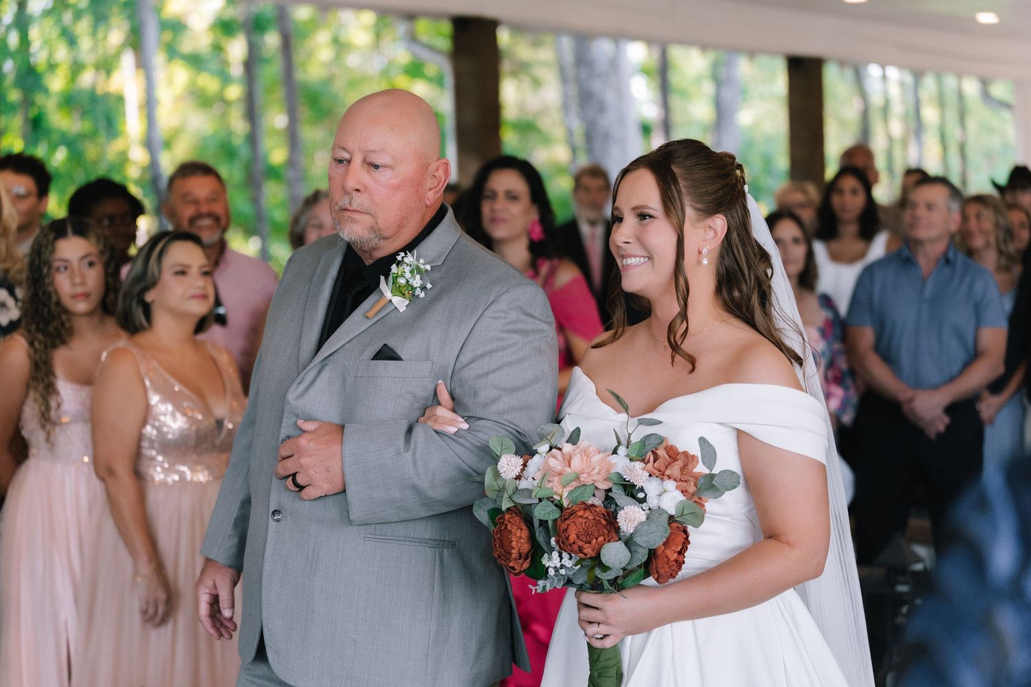 Wedding reception guests dance and celebrate on an outdoor covered patio.