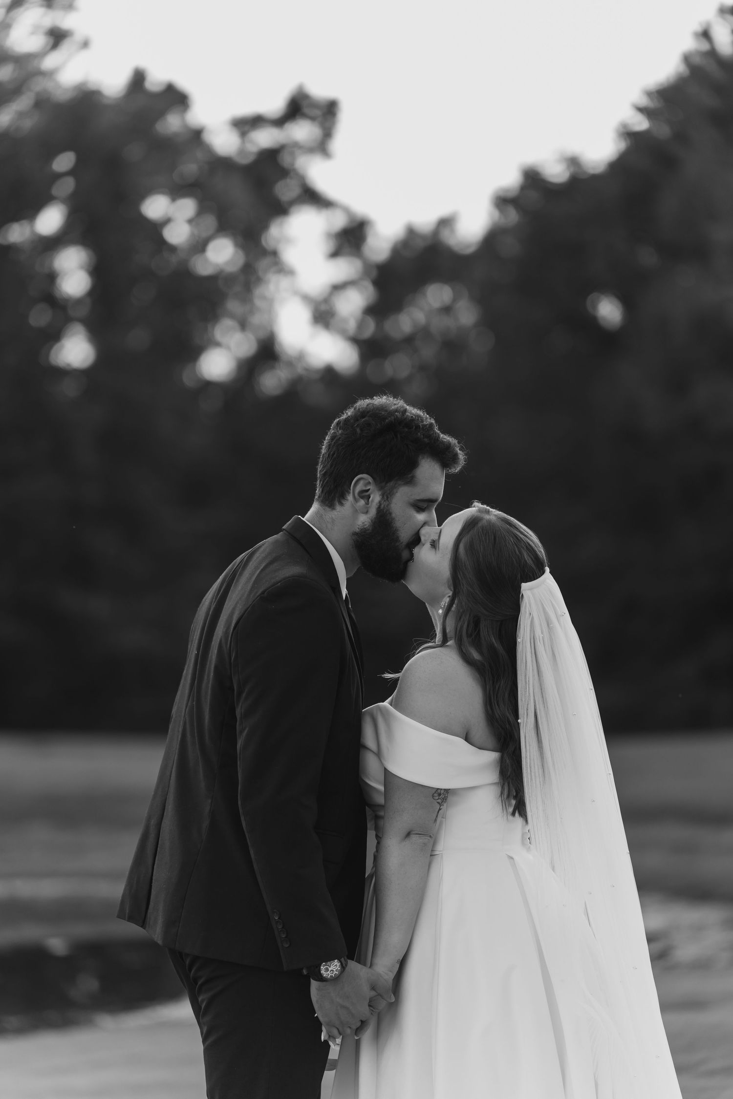 An intimate black and white wedding photo shows the couple in a tender moment on their special day.