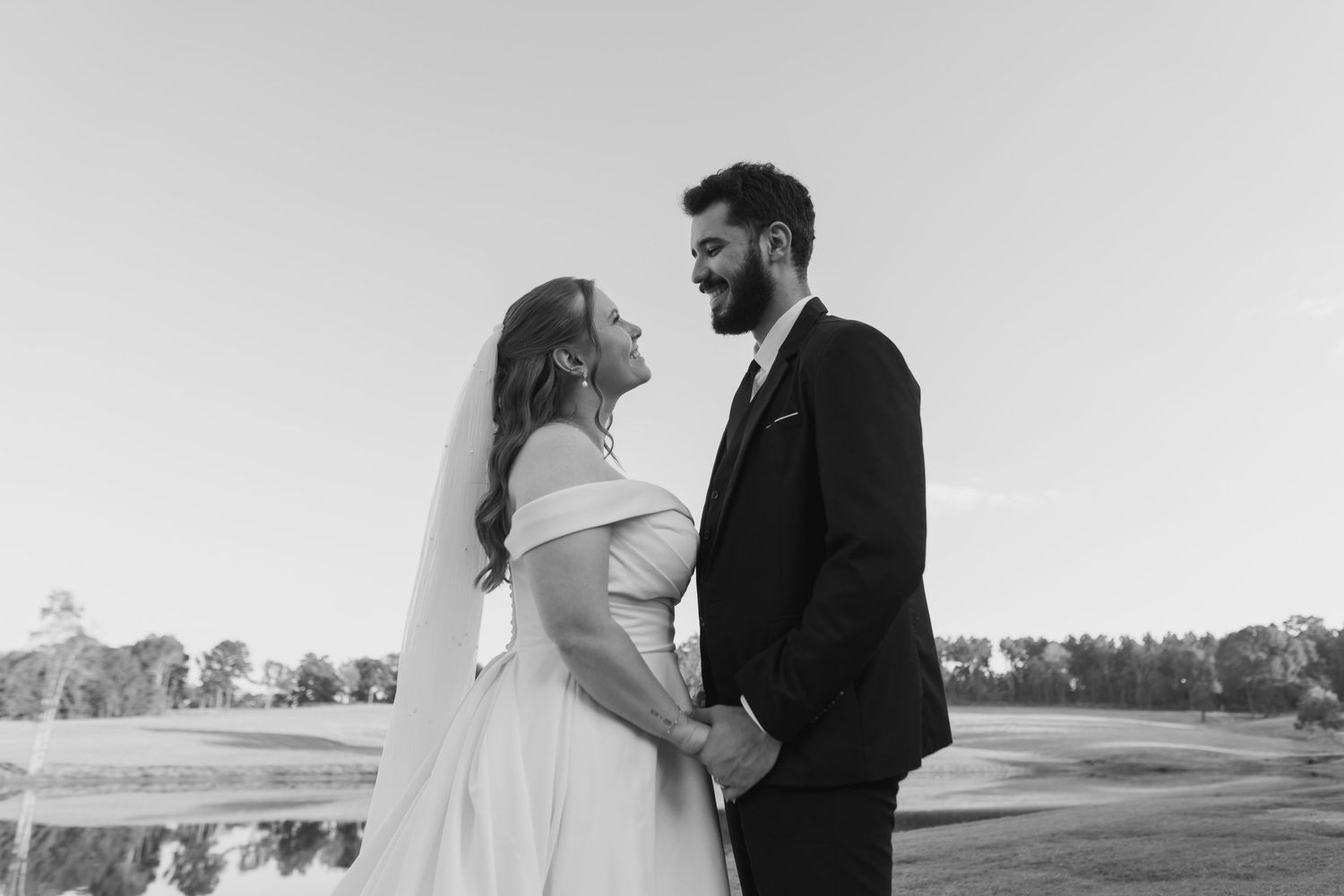 A romantic wedding couple embraces in a scenic outdoor setting during their special day.