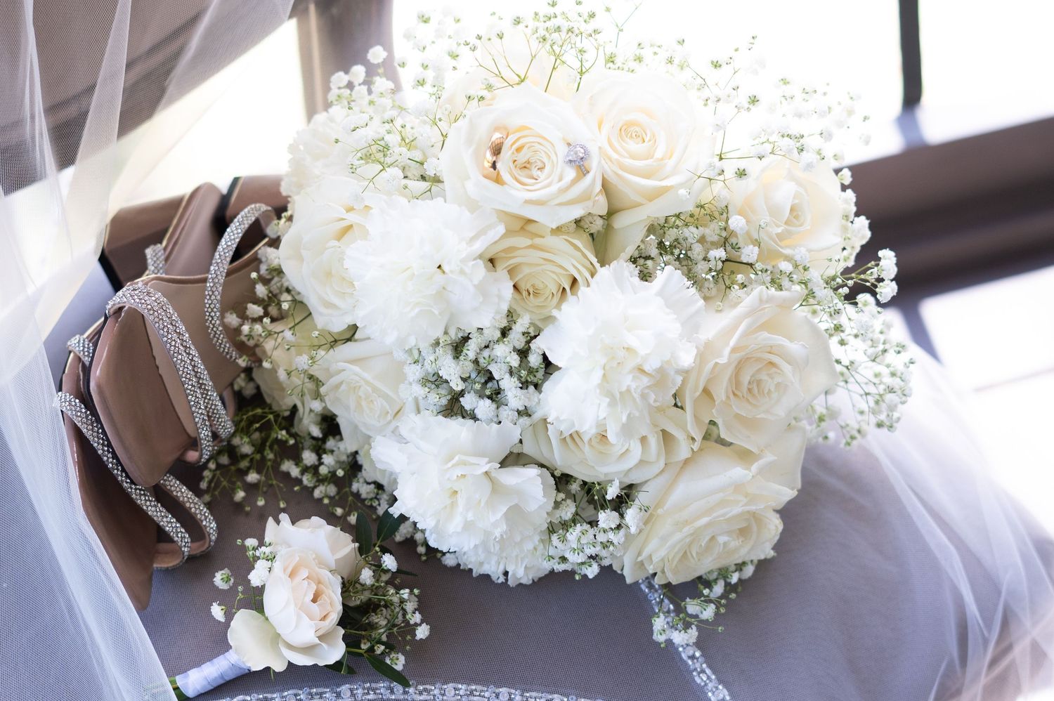 White roses and baby's breath floral arrangements displayed in elegant glass vases for a wedding celebration.