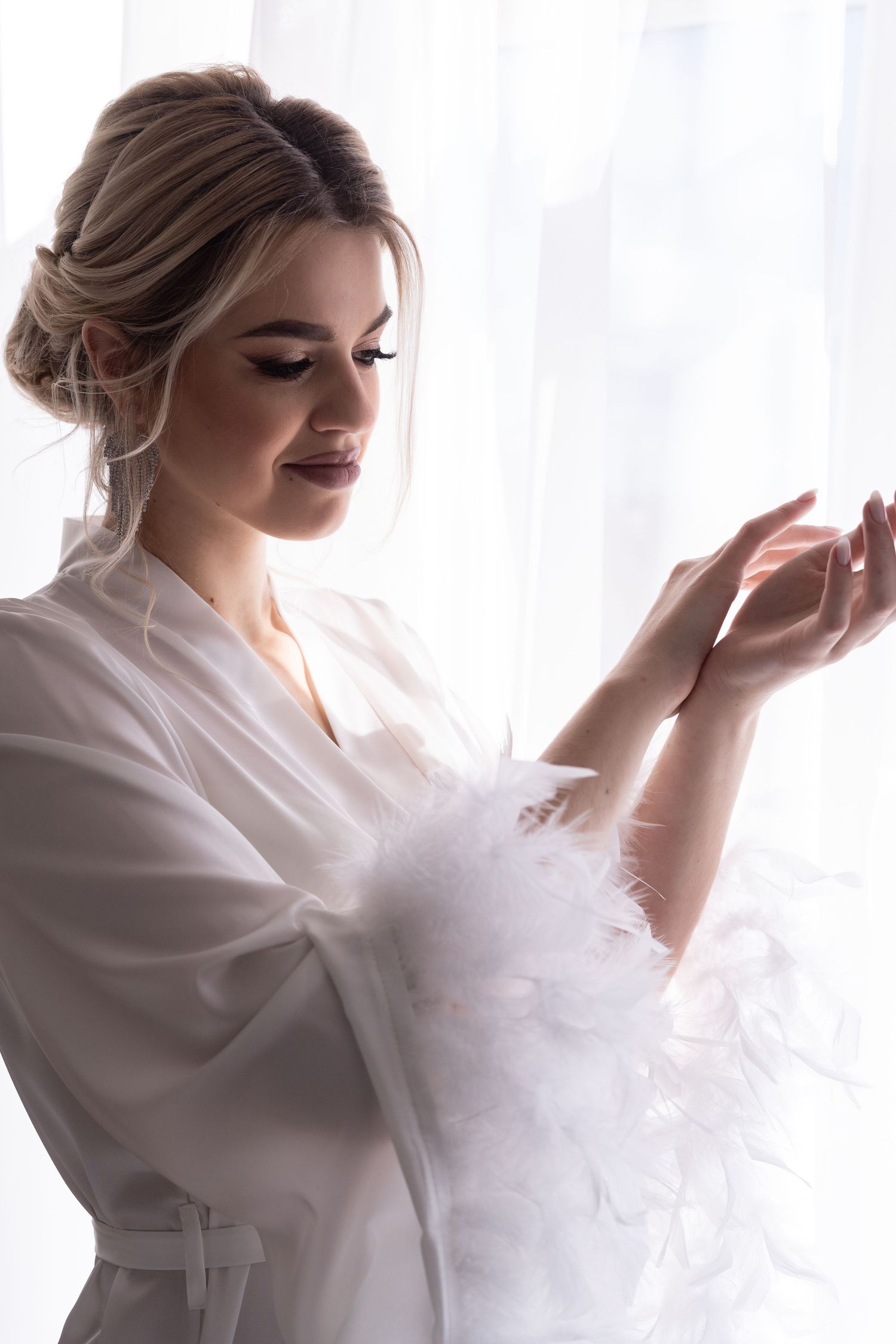 A series of ethereal boudoir photos showing a woman in a white robe posing gracefully against natural light.