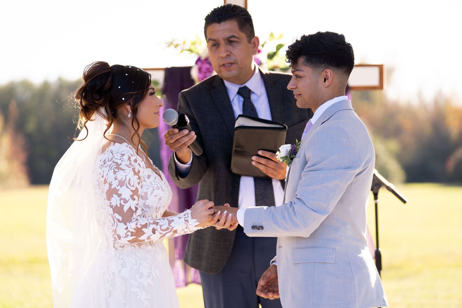 Wedding ceremony participants gather outdoors during golden hour for emotional moments.