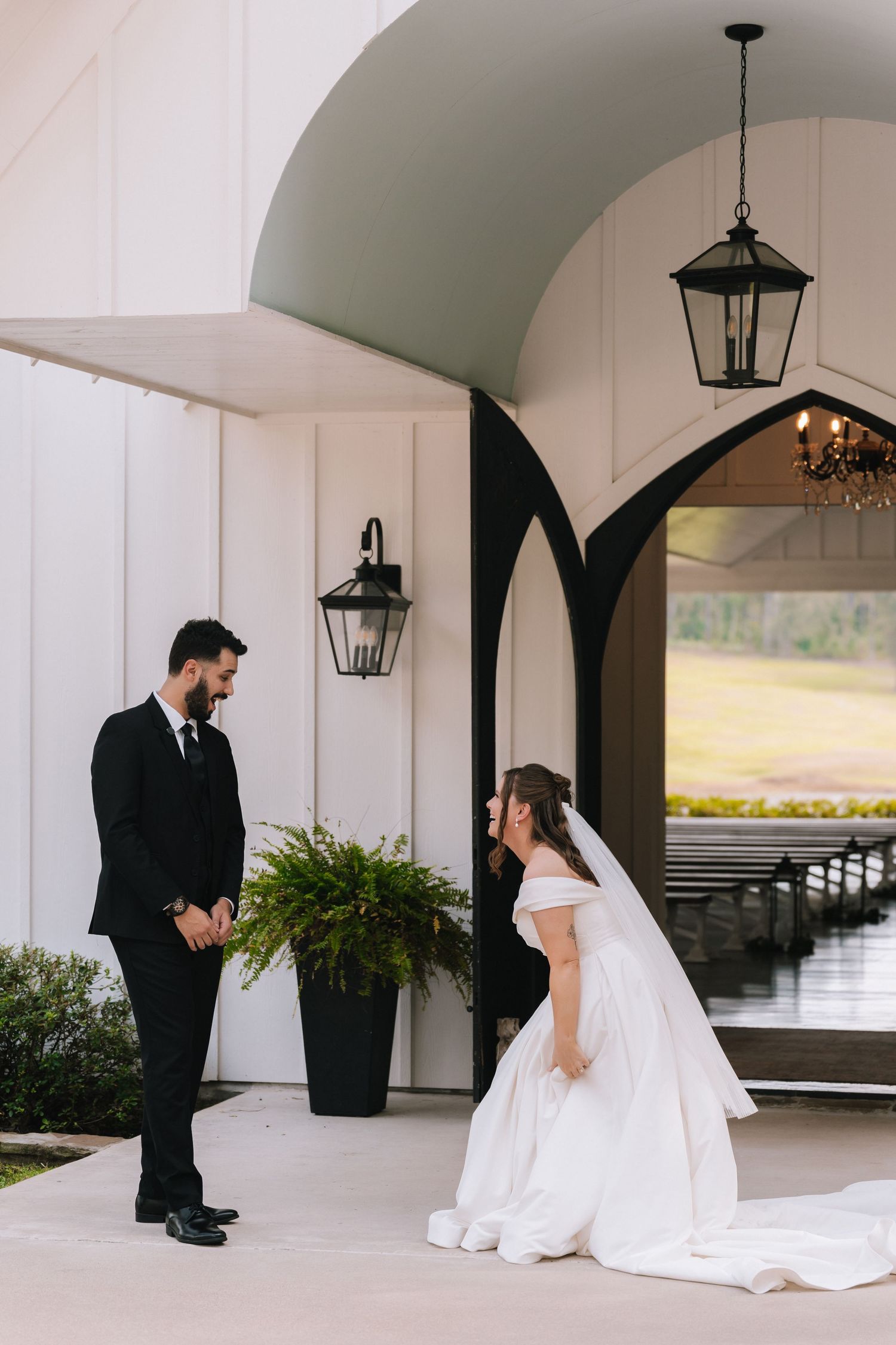 Wedding first look sequence showing couple meeting under white arched walkway with hanging lanterns.